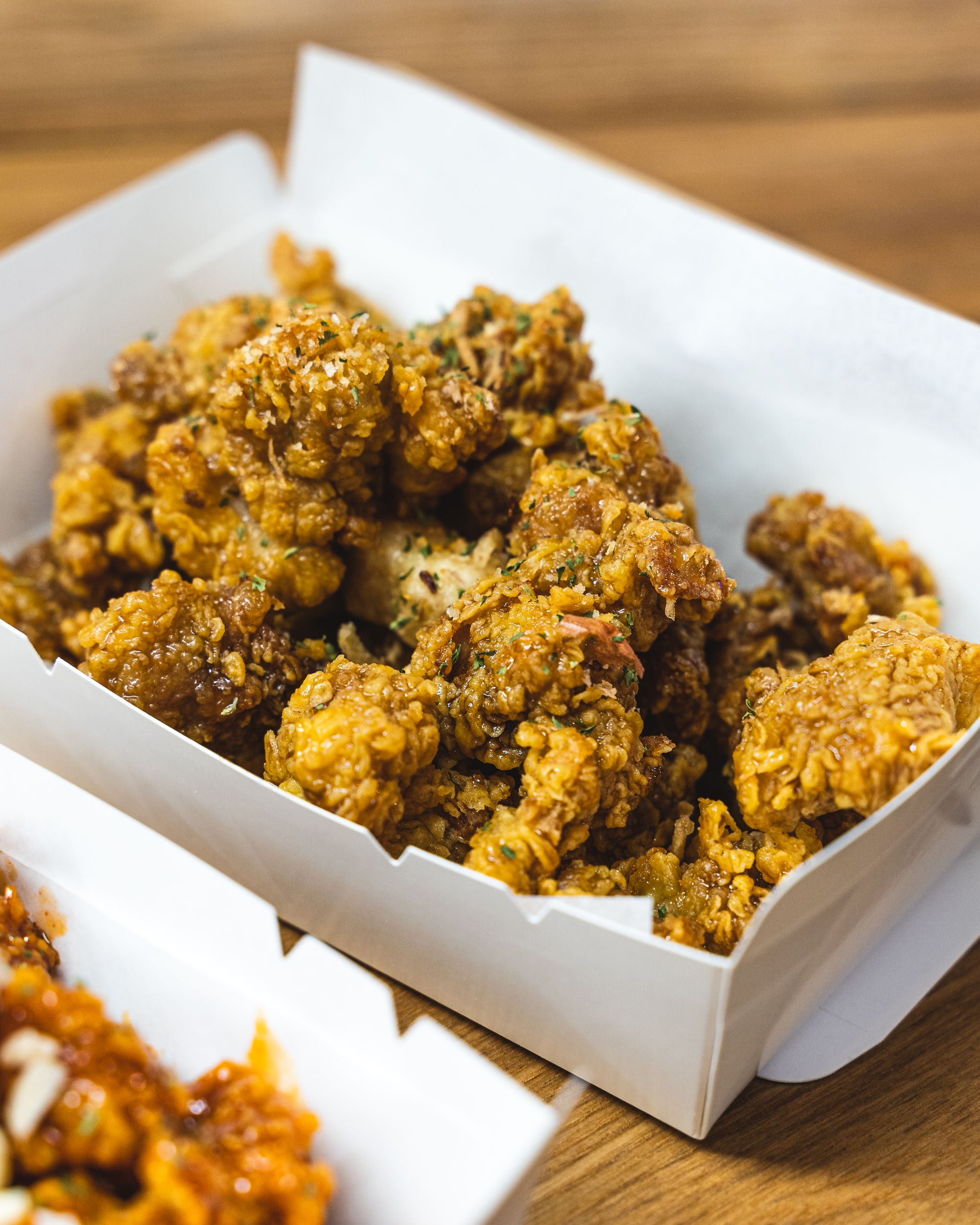 Close up shot of Korean fried chicken in a paper box