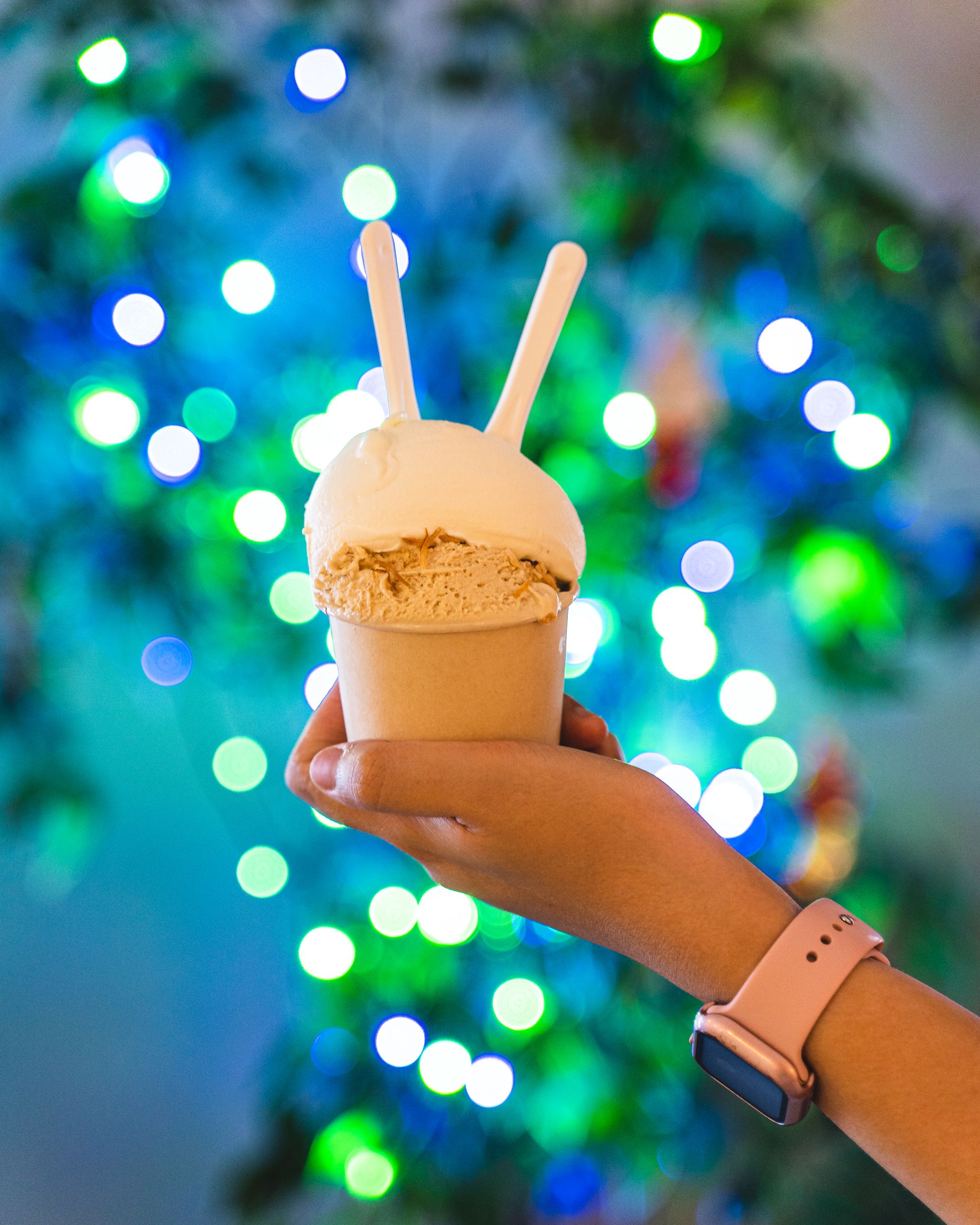 Gelato in a cup being held in front of lights