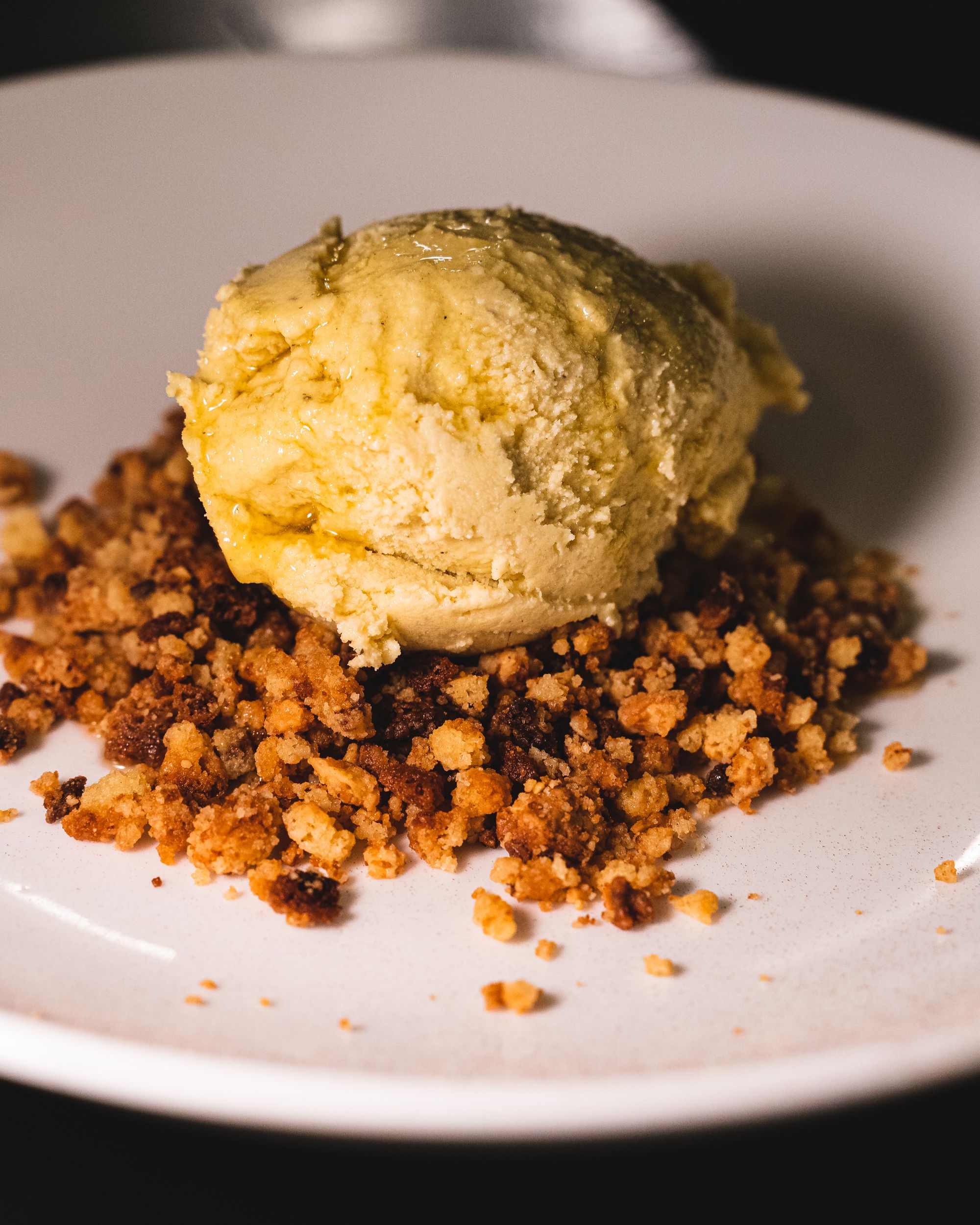 Close up cake crumbs and a scoop of ice-cream on-top