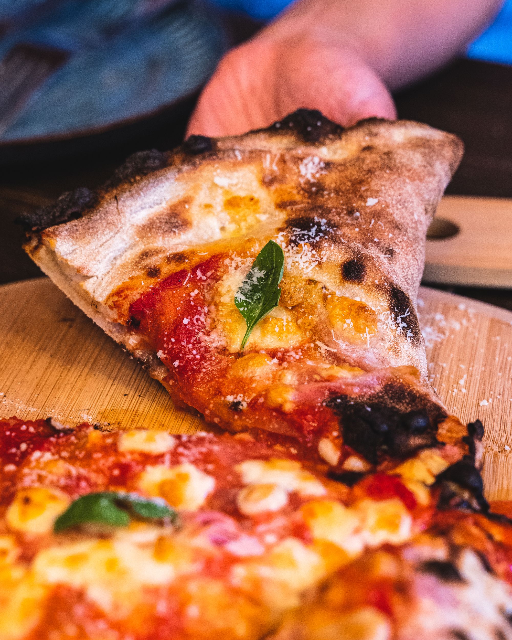 Hand lifting up a slice of pizza