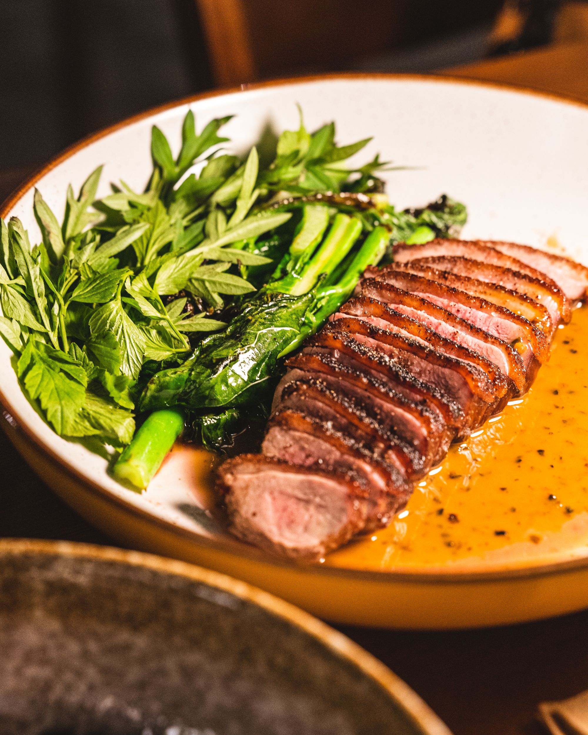 Grillde aged duck with market greens and sauce poivrade