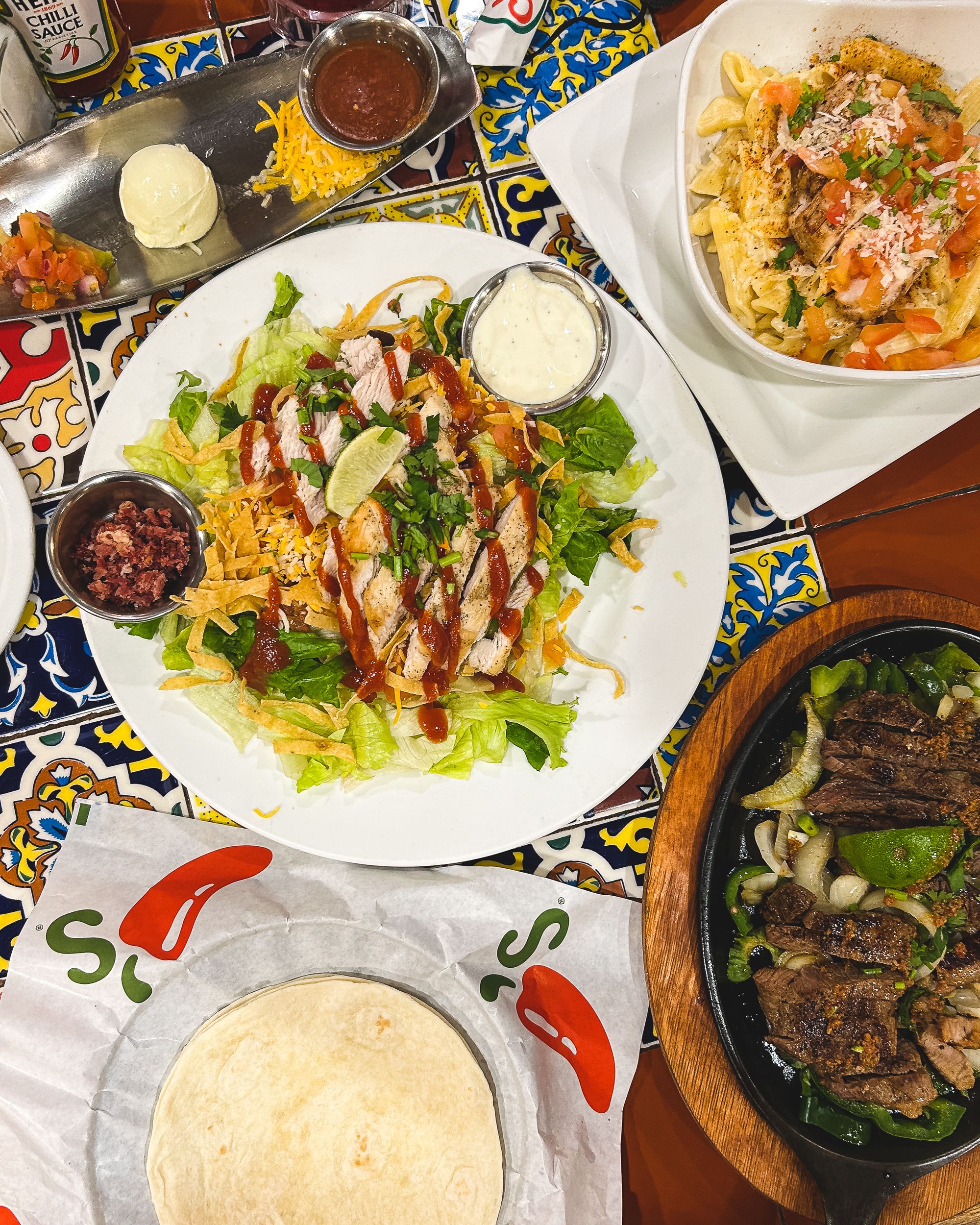 Top down shot of BBQ chicken salad, fajitas and Cajun pasta