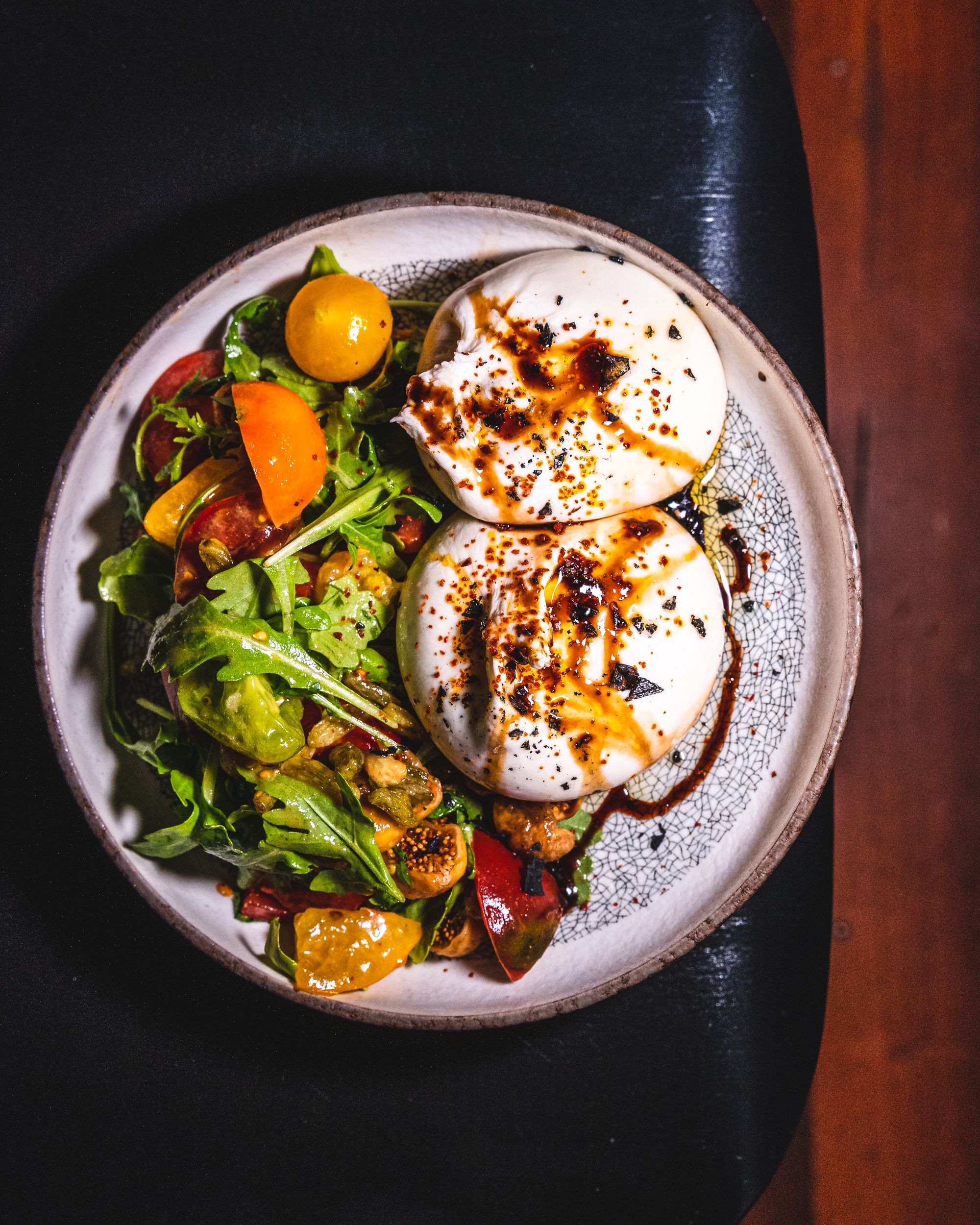 Top down shot of burrata with tomato salad