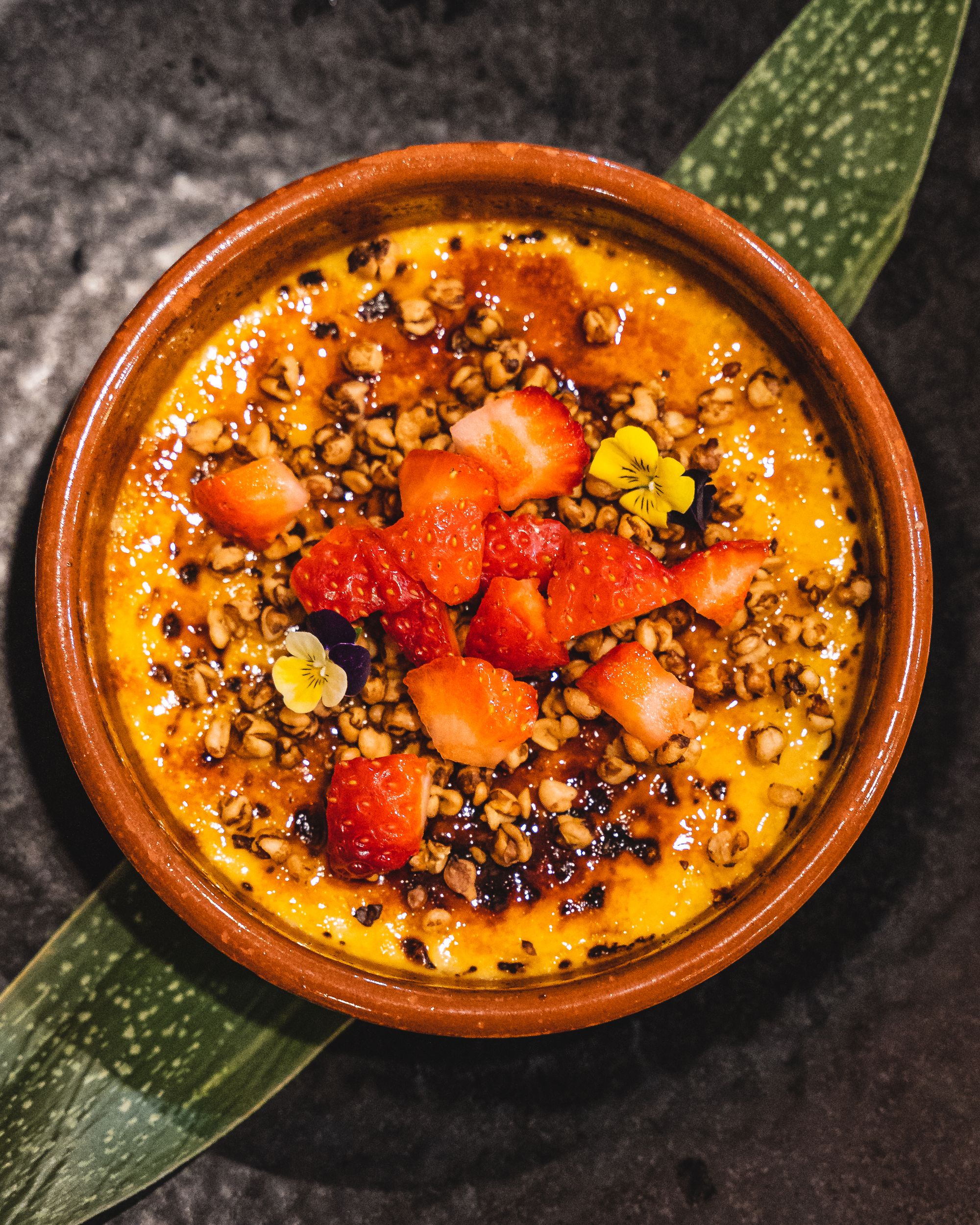 Close up of miso creme brulee, topped with fruit