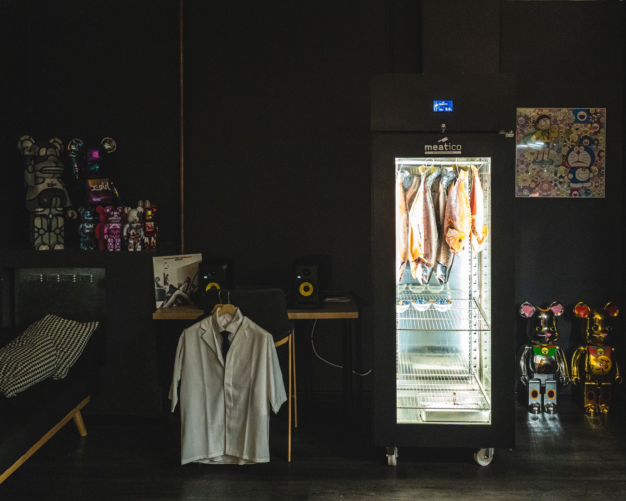 Interior of Omakase Haku showing Japanese chef uniform, bearbricks and a dry age fridge