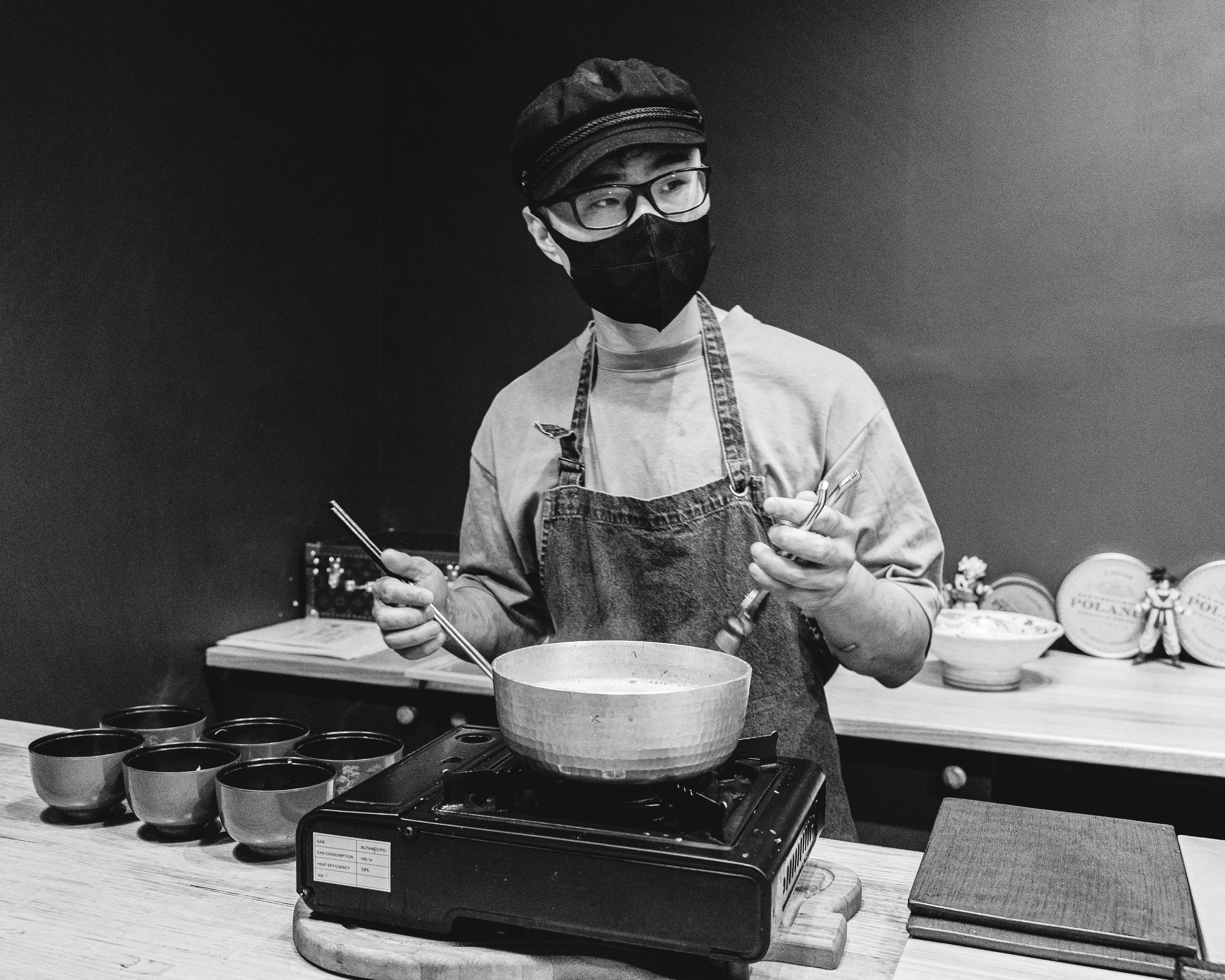 Chef cooking broth on a steel pot