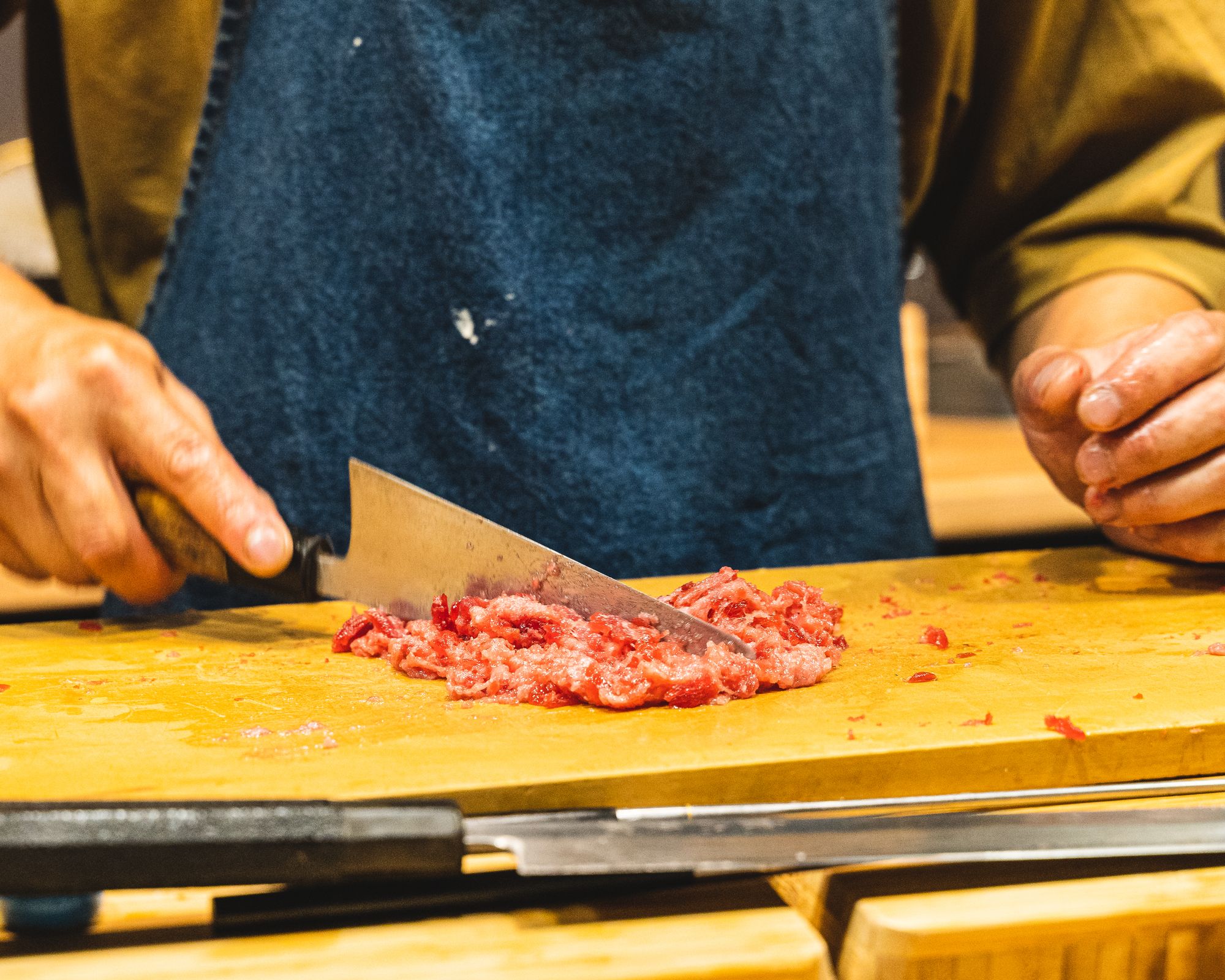 Chef mincing tuna meat