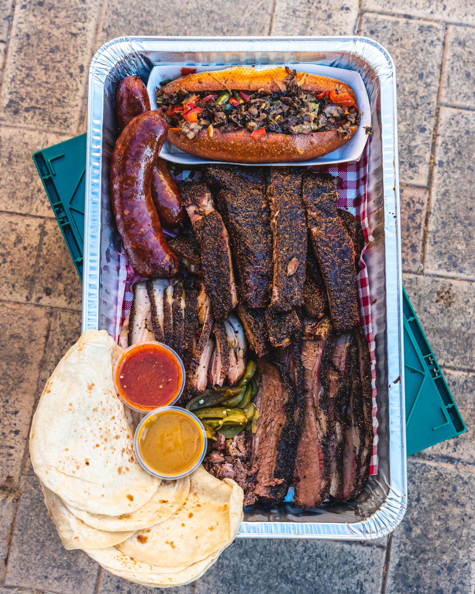 Top down shot of BBQ platter with tortillas on a aluminium tray