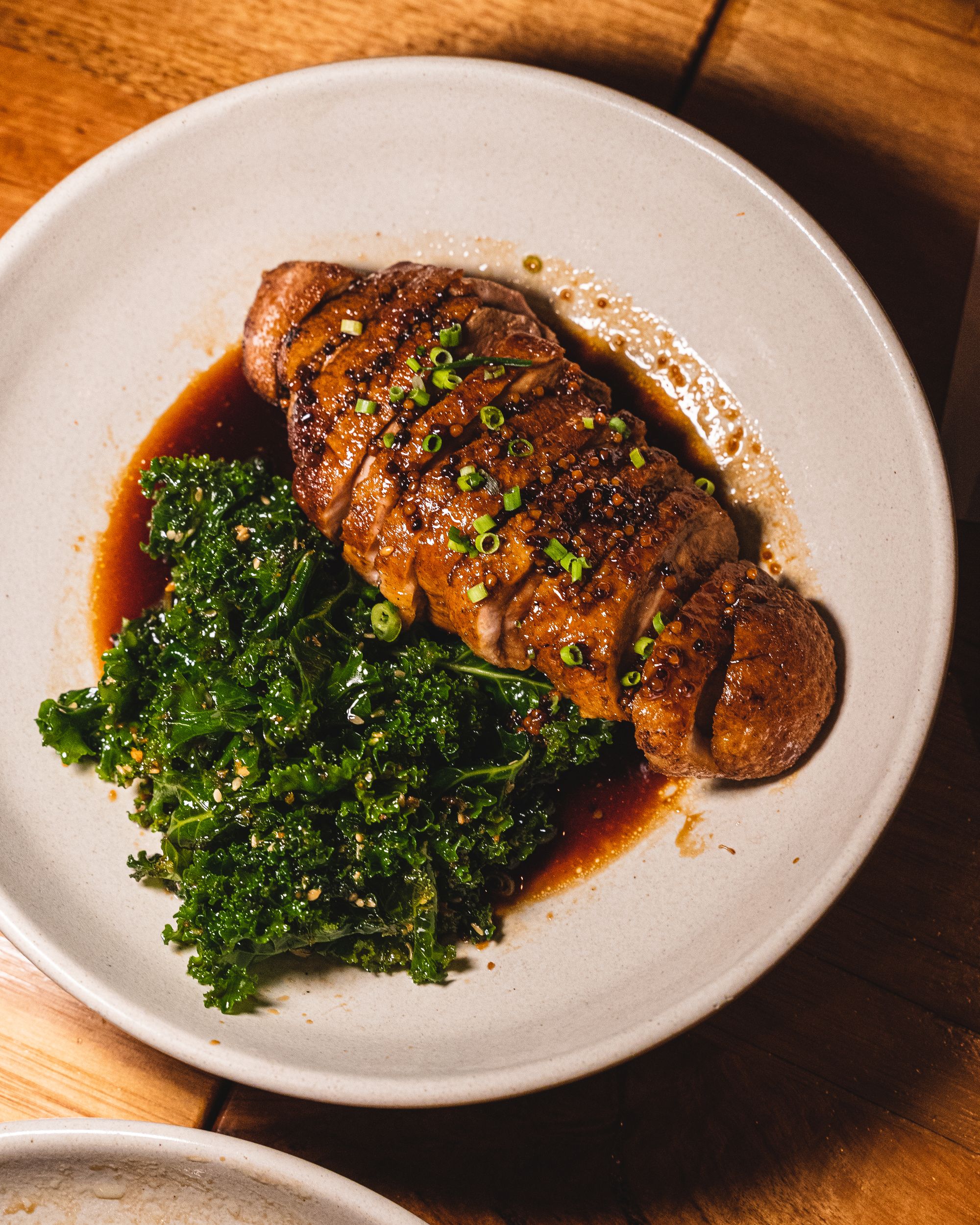 Top down shot of duck with spring onions and kale