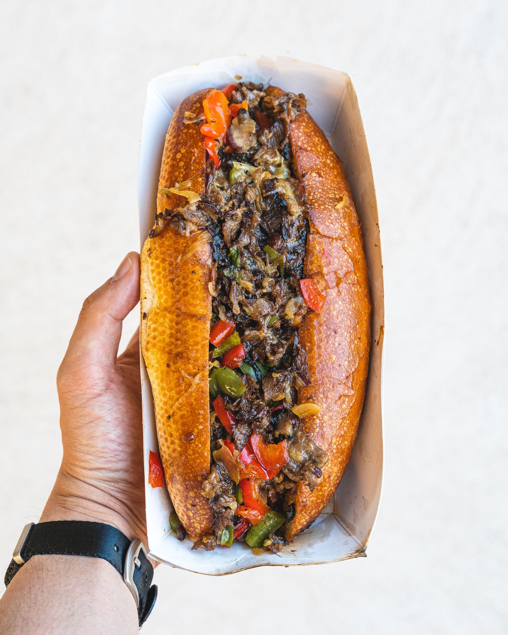 Hand holding a cheesesteak