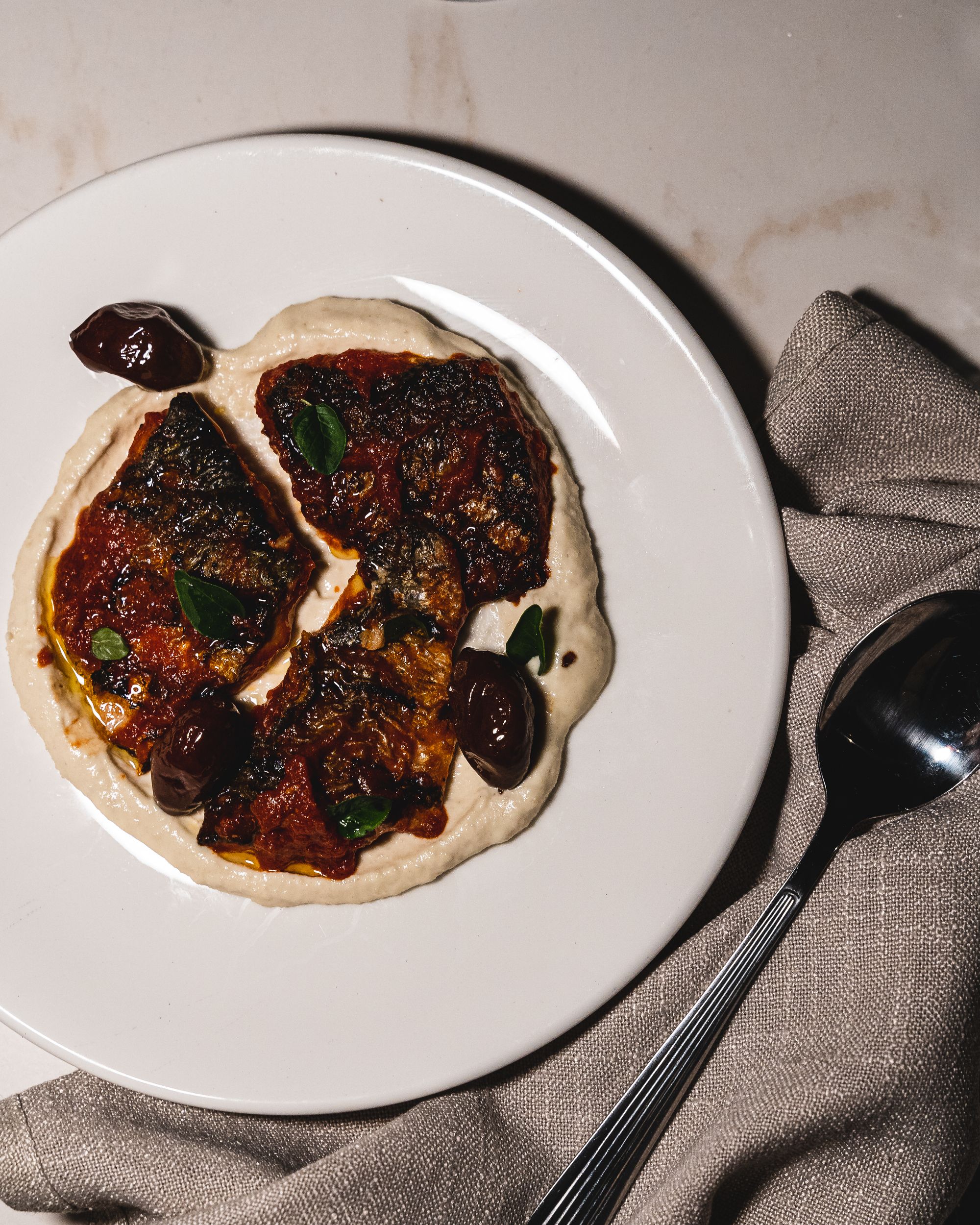 Top down of charred mullet with creamy sauce