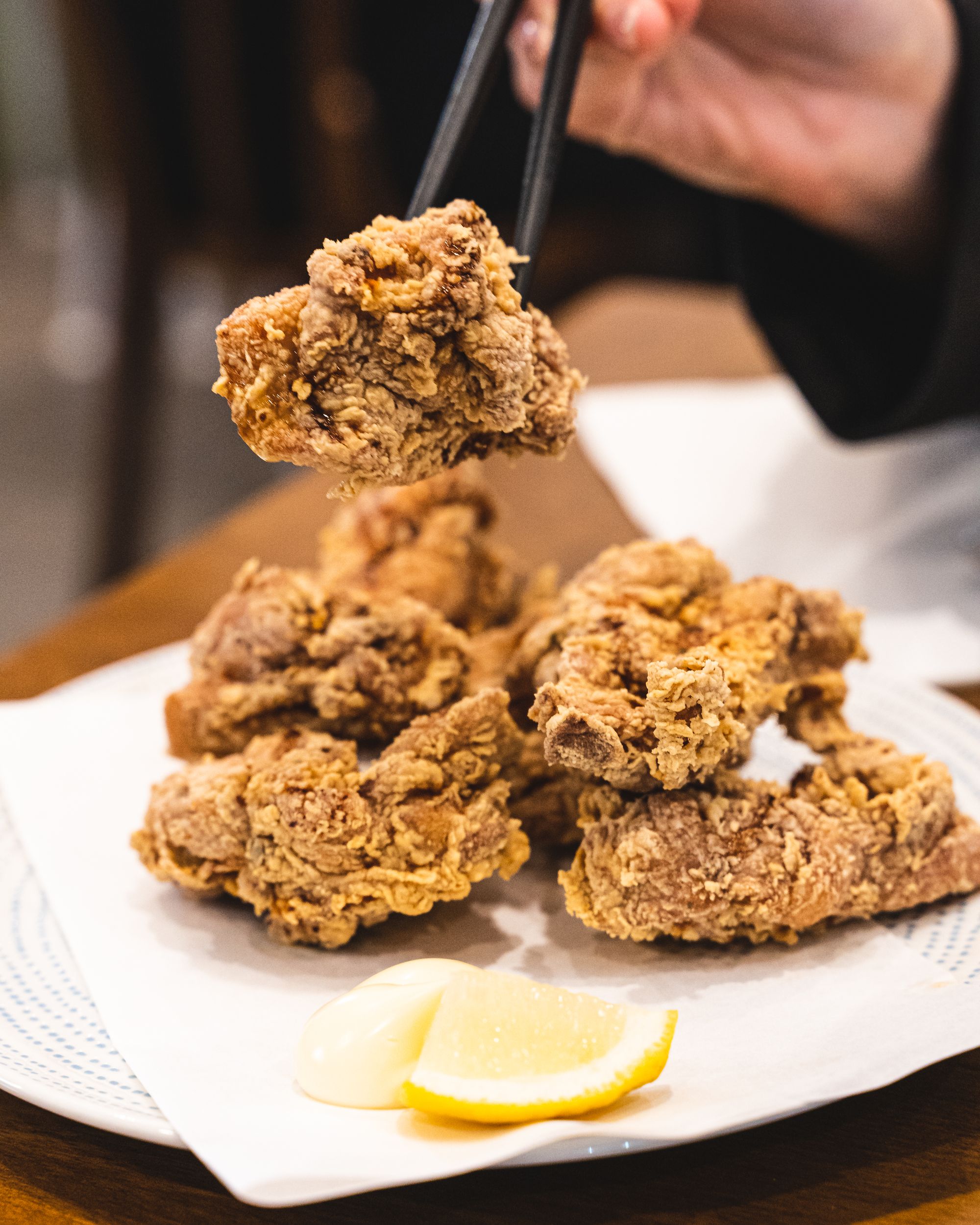 Chopsticks picking up pieces of karaage chicken