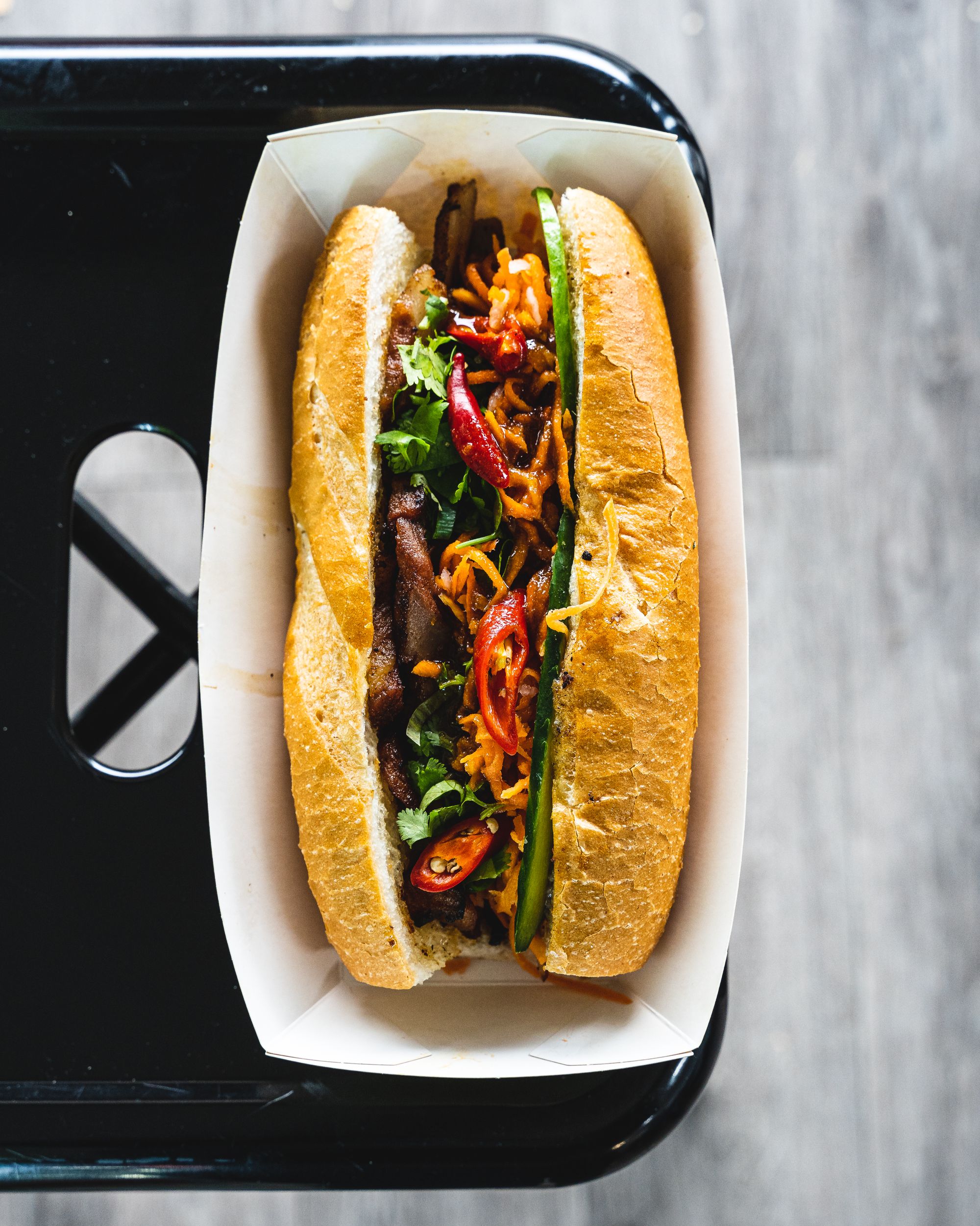 Top down shot of BBQ pork banh mi with chilli and coriander