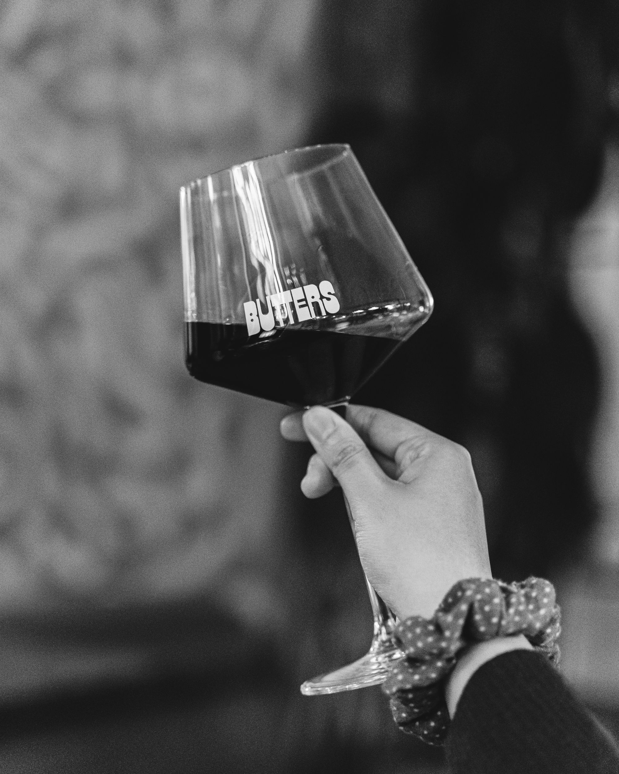 Hand holding a wine glass filled with red wine