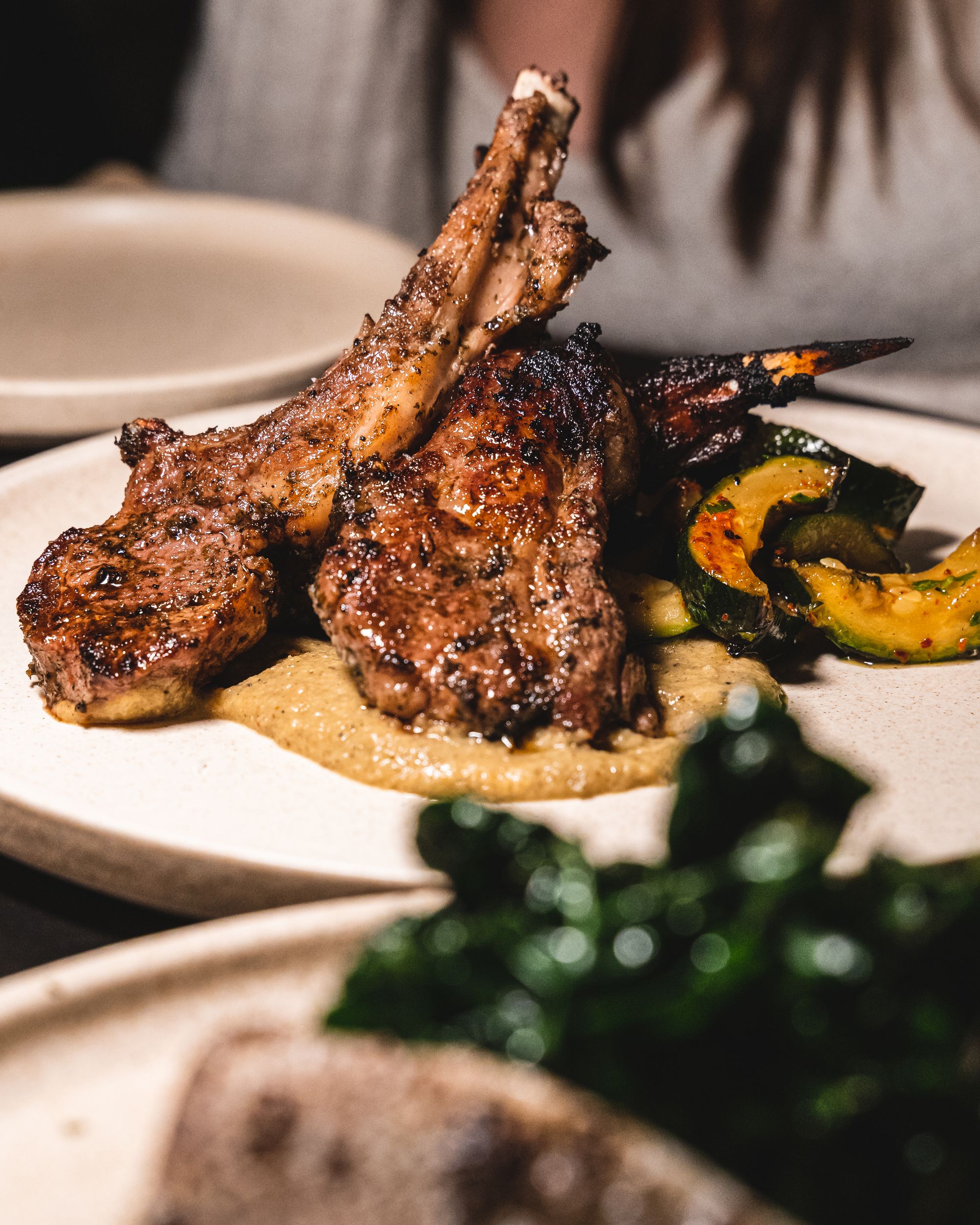 Close up of lamb chops with zucchini and baba ganoush 