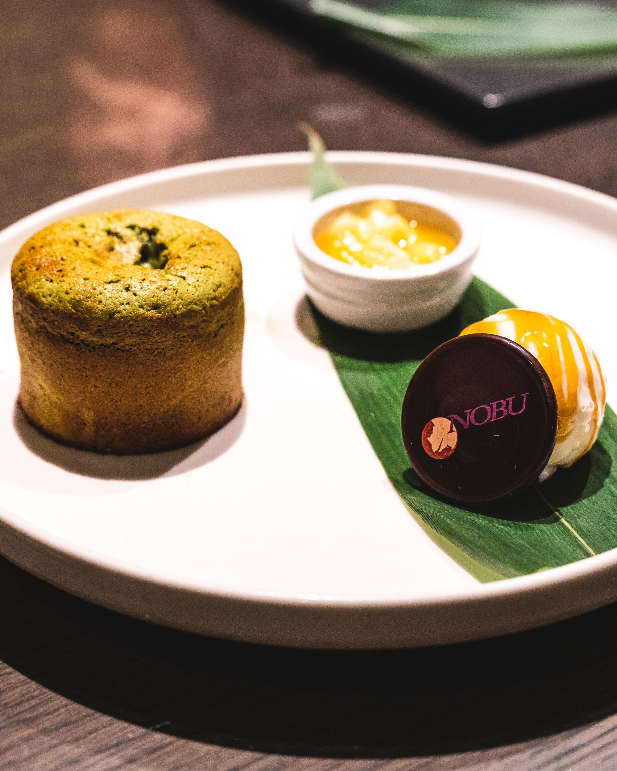 Unbroken lava cake, ice-cream, fruit compote and a circular chocolate with NOBU written on it