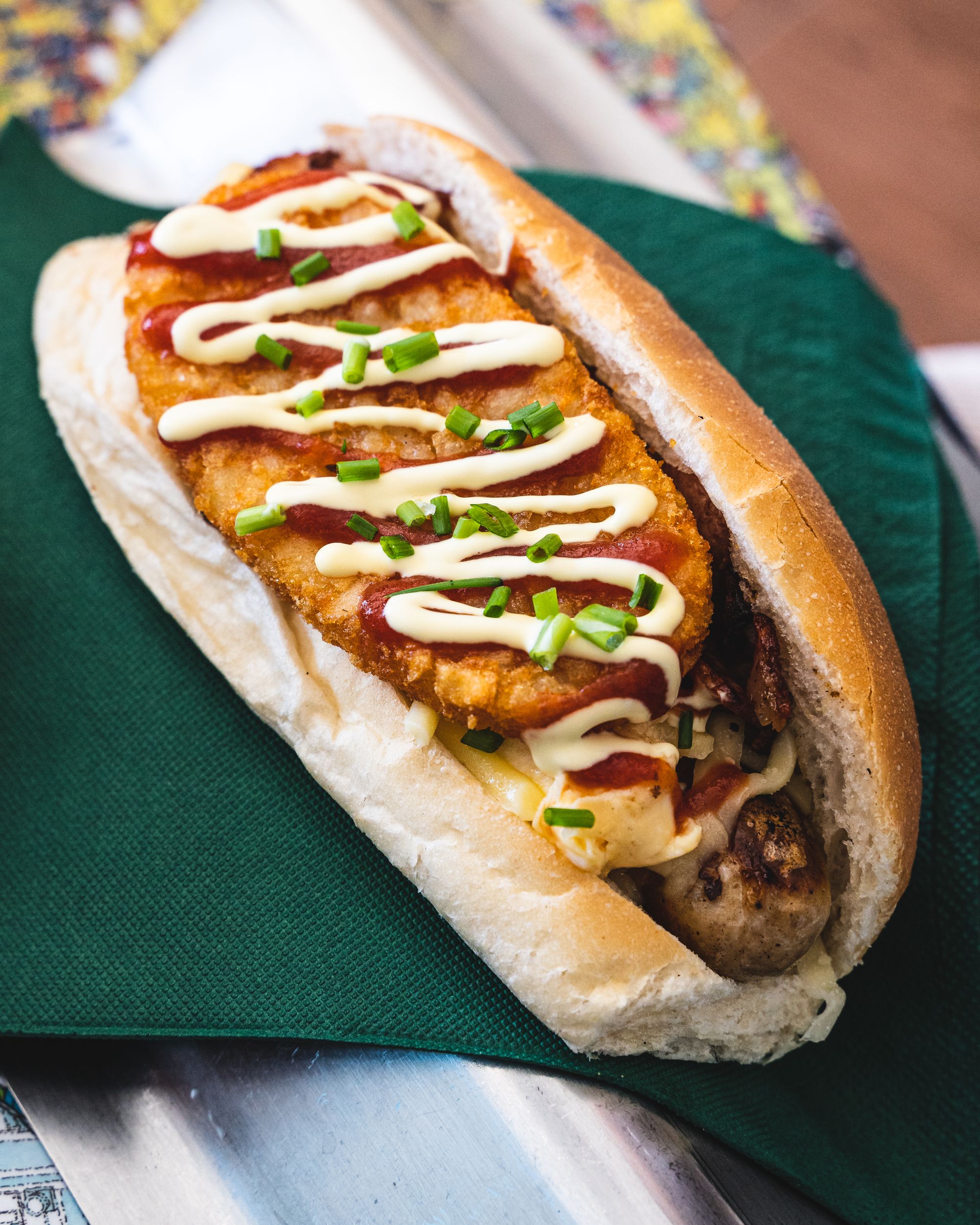 Hot dog with hashbrown, mayo and chives