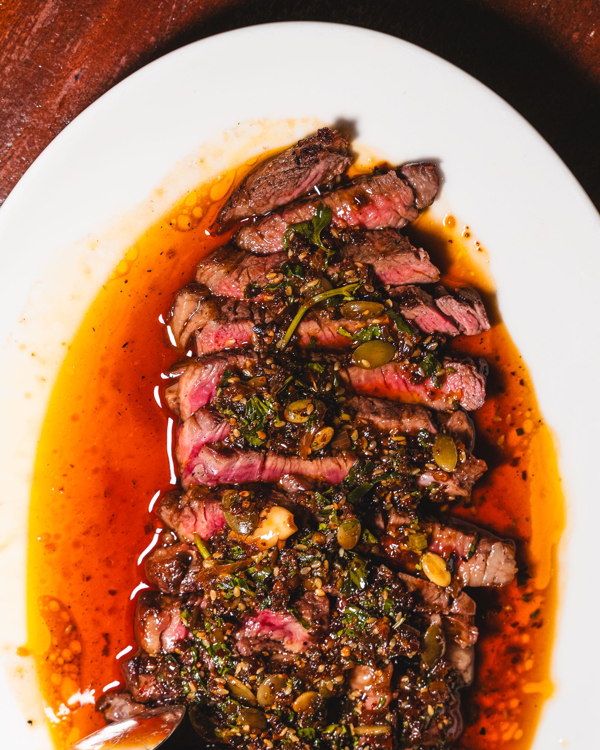 Top down shot of Scotch fillet steak in a salsa macha and pepita sauce