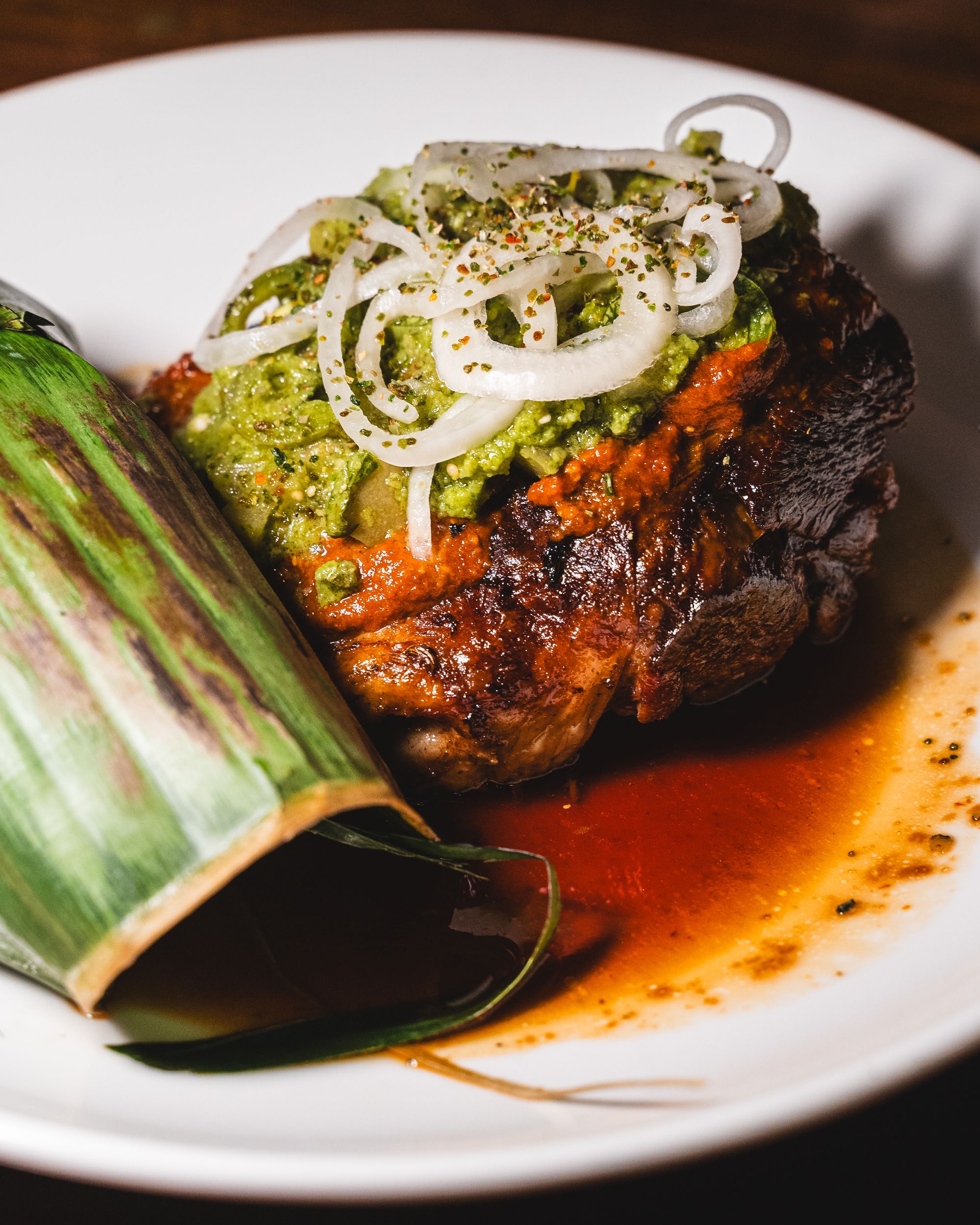 Close up of pulled lamb with onion garnish and avocado