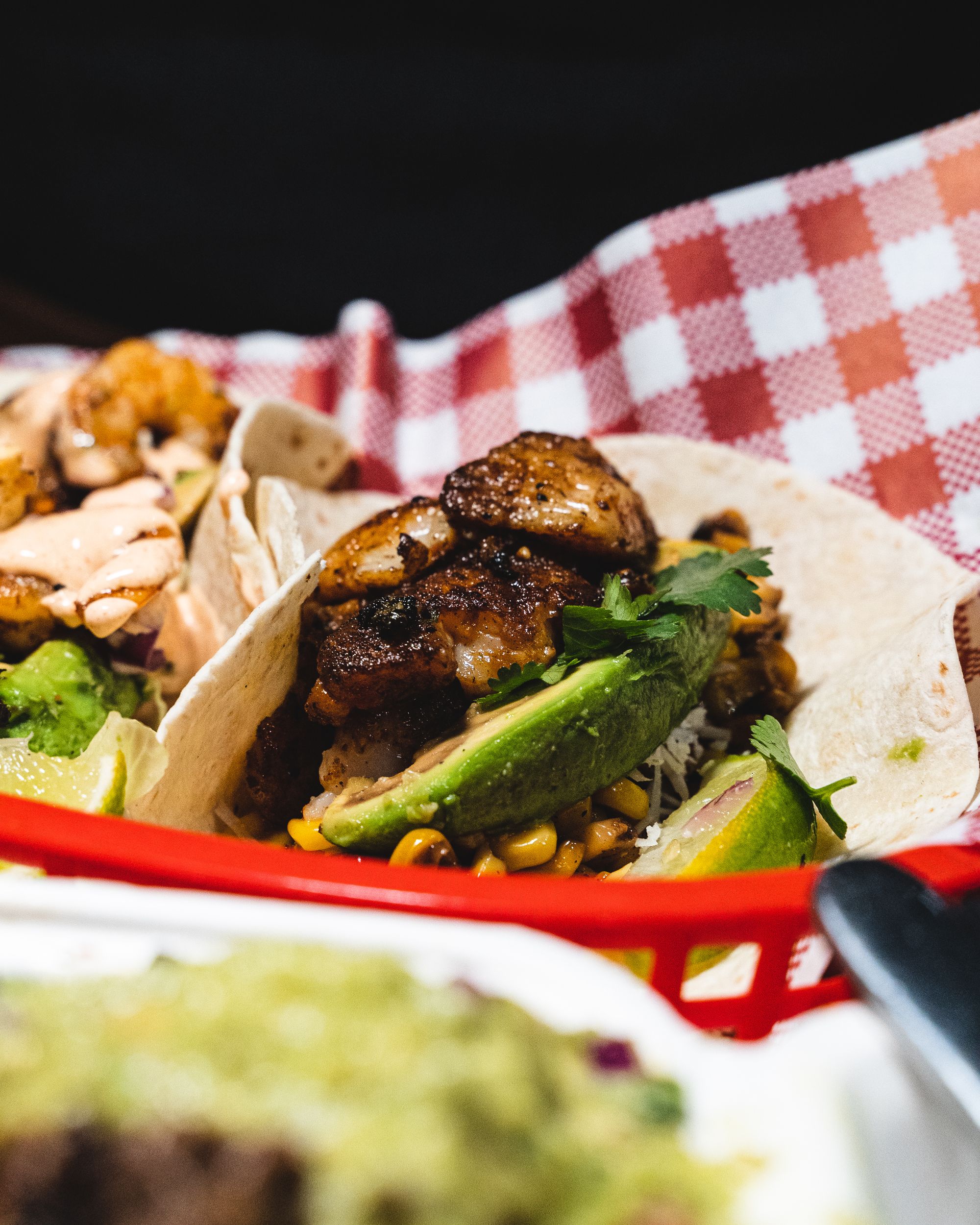 Close up of fish tacos with avocado and corn