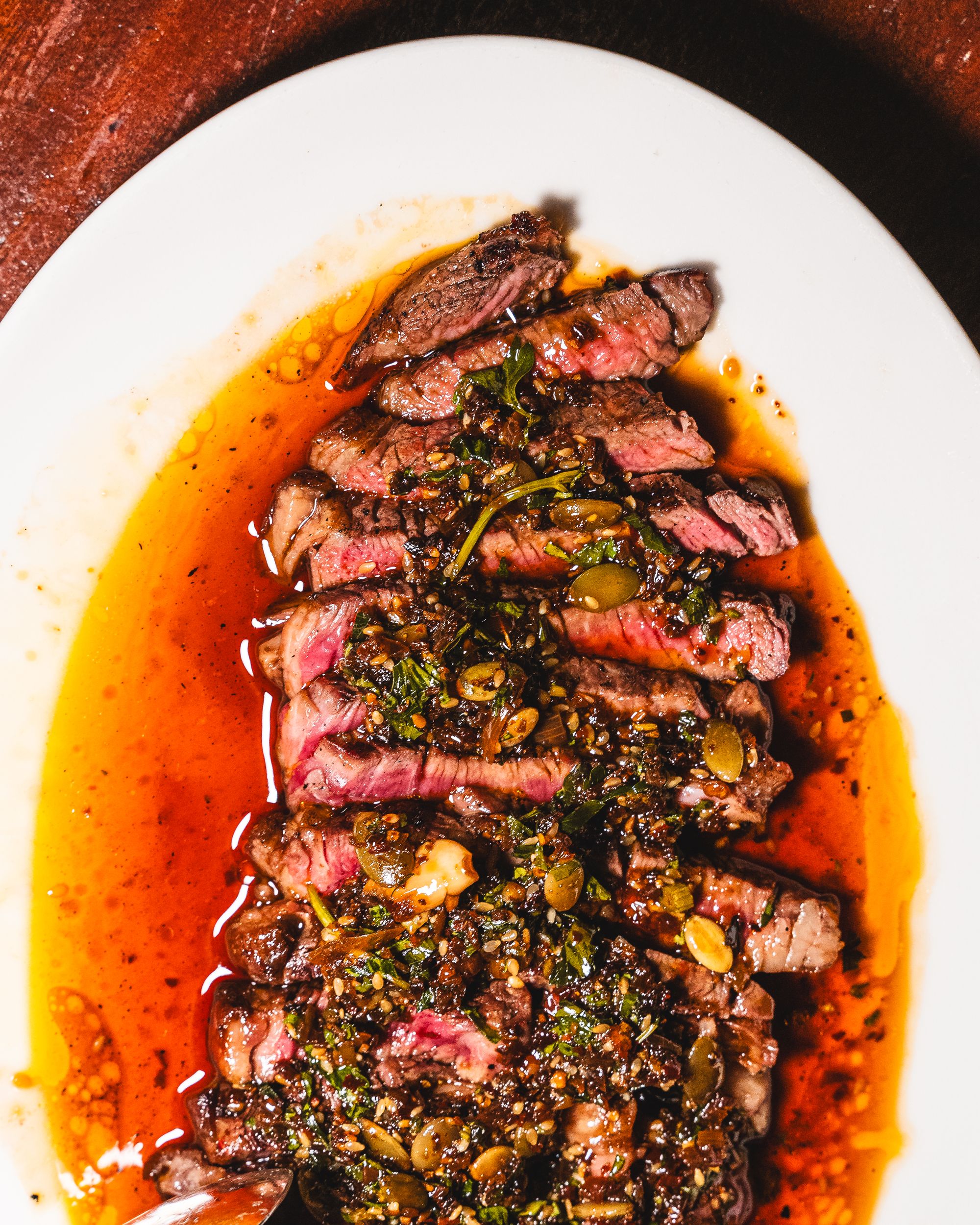 Top down shot of steak in salsa macha and pepita