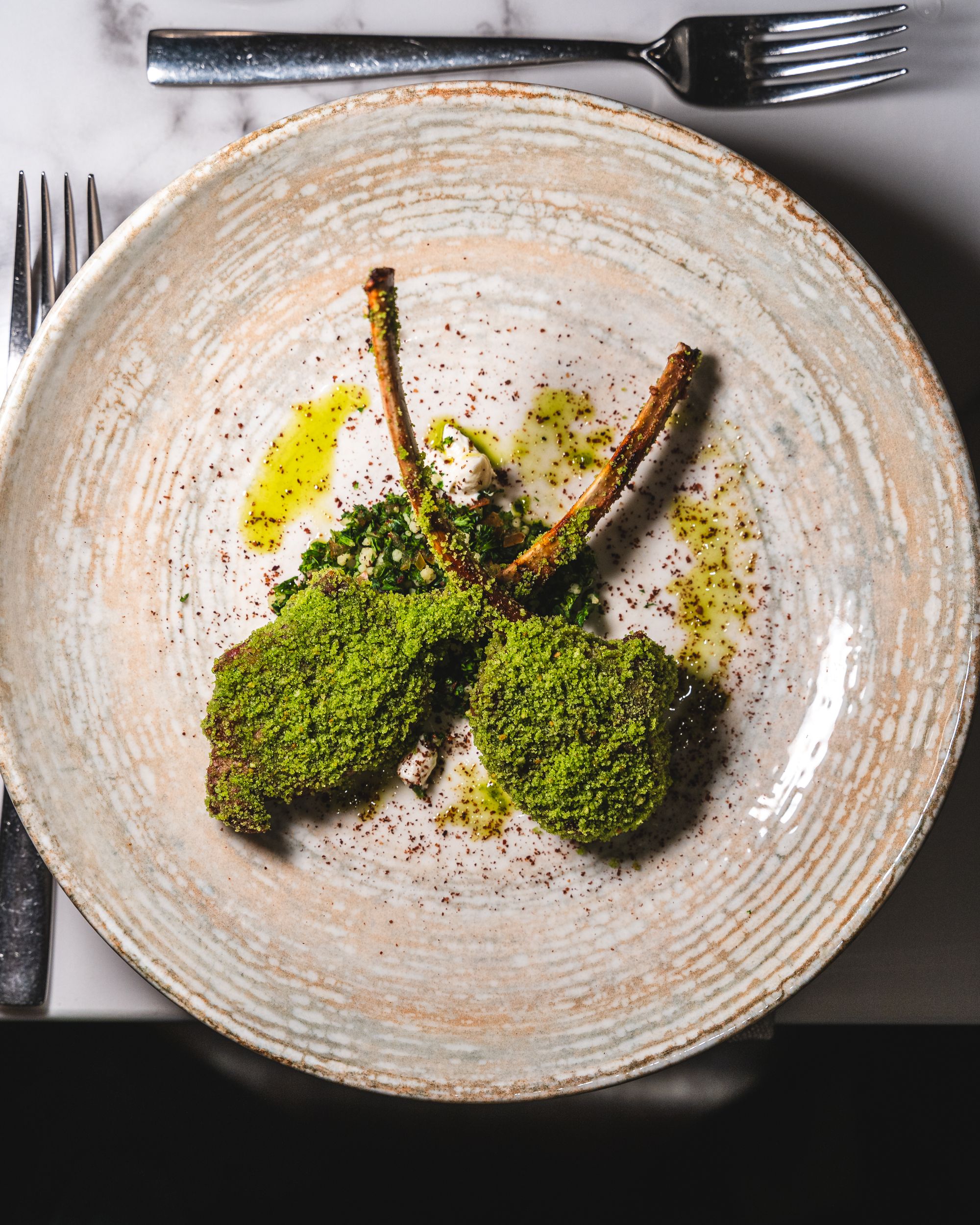 Top down shot of lambchops coated in tabbouleh