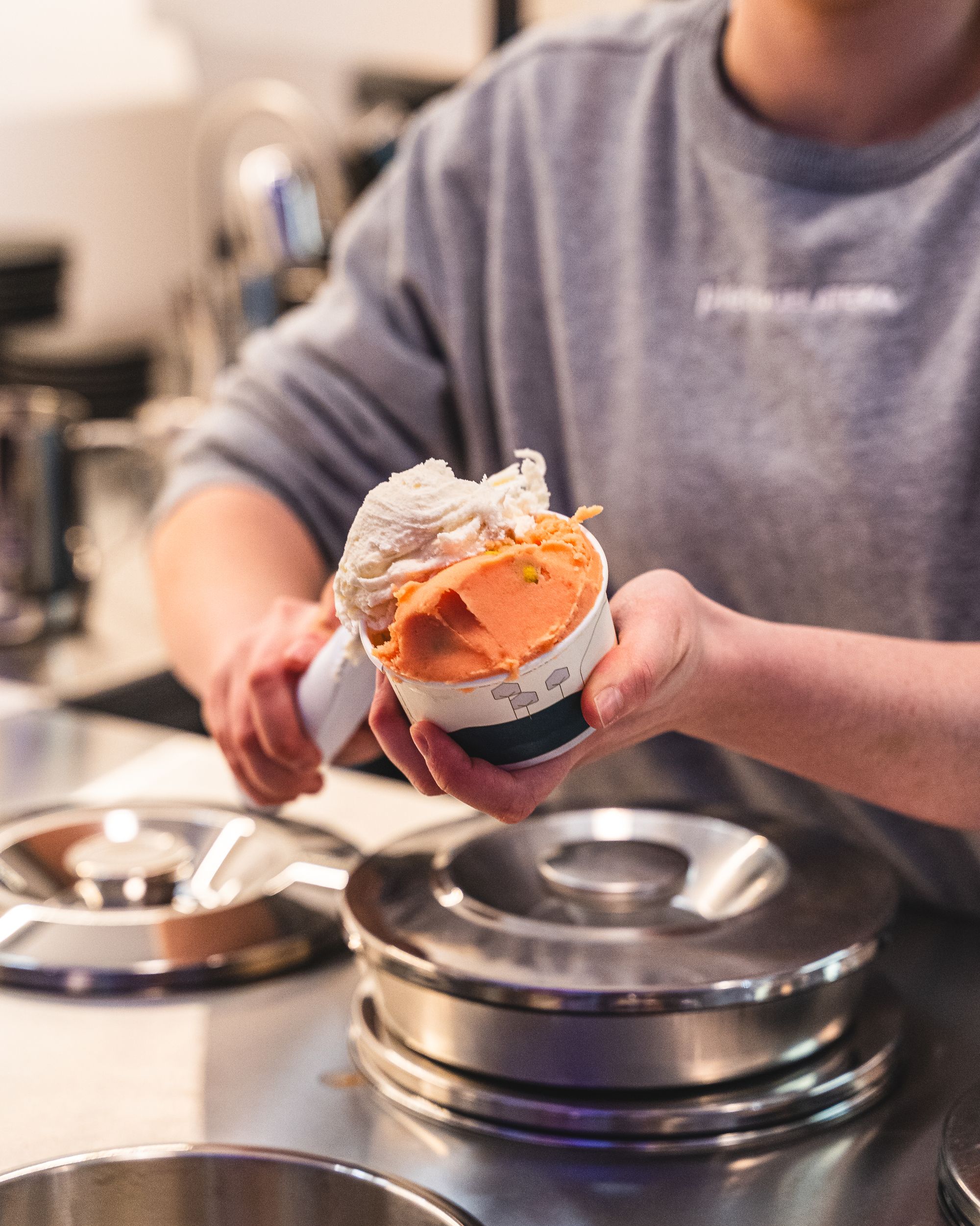 Hand scooping gelato into a cup