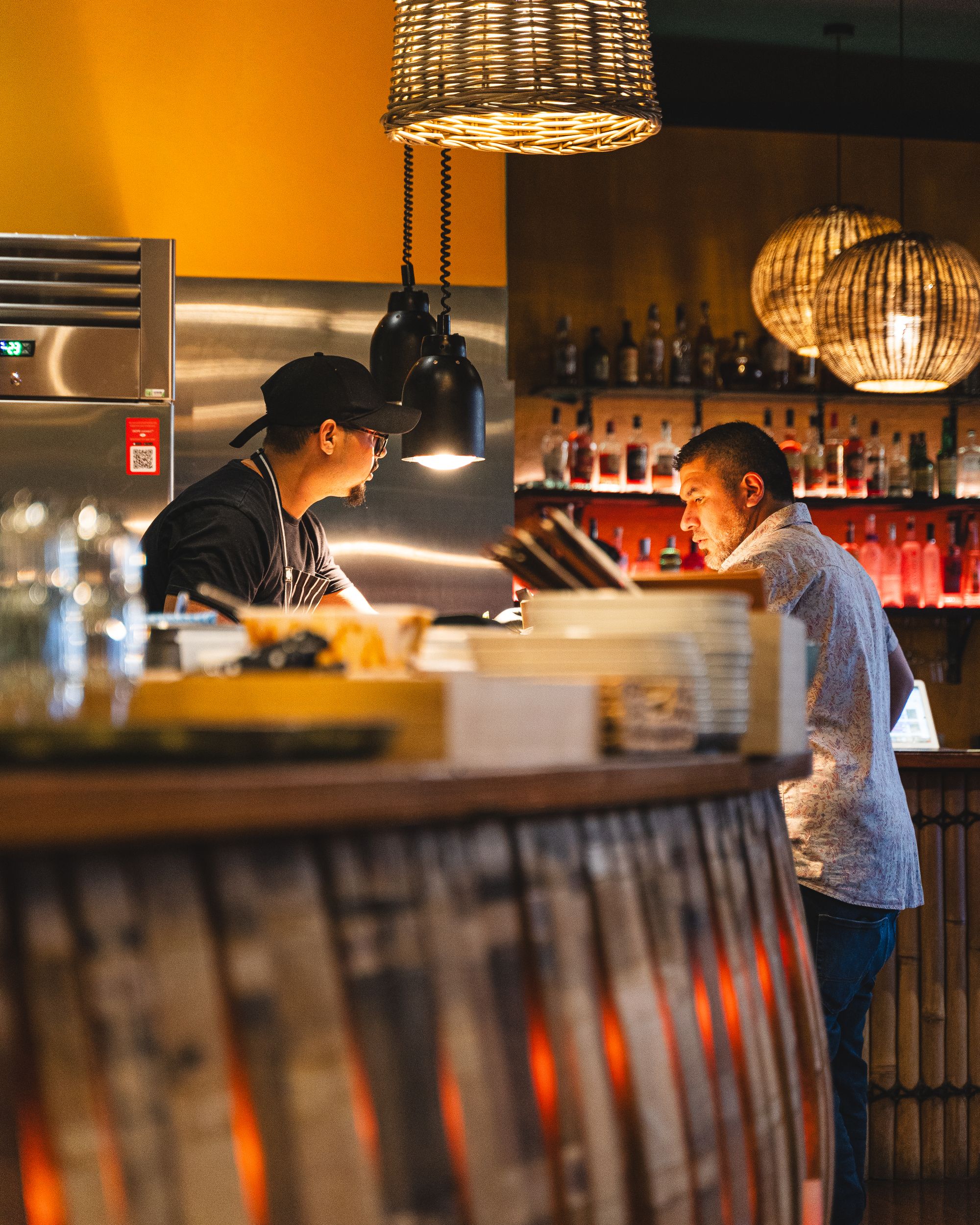 Candid photo of staff waiting by a kitchen counter inside of a restaurantCandid photo of staff in a restaurant