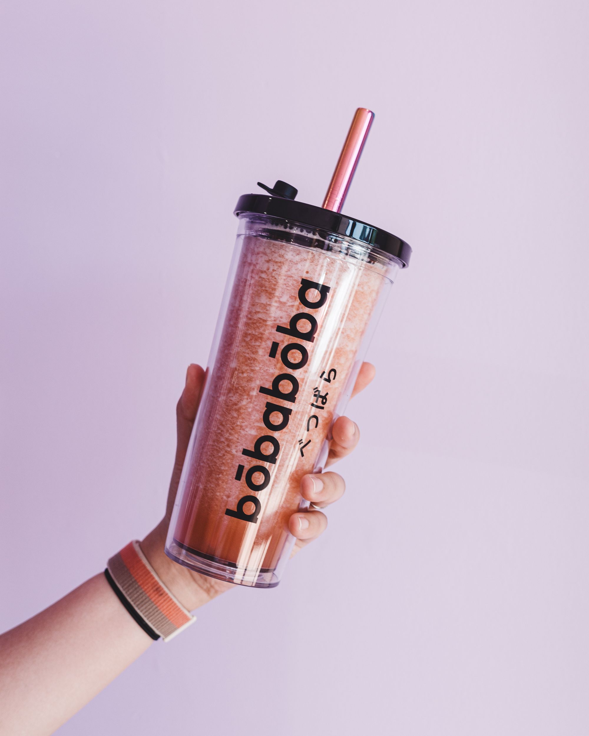 Hand holding a bobaboba branded reusable bubble tea cup