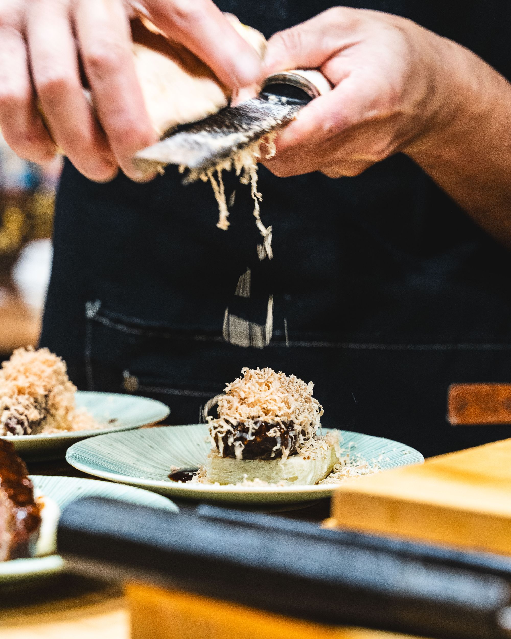 Close up of foie gras being shaved onto a dish with a microplane