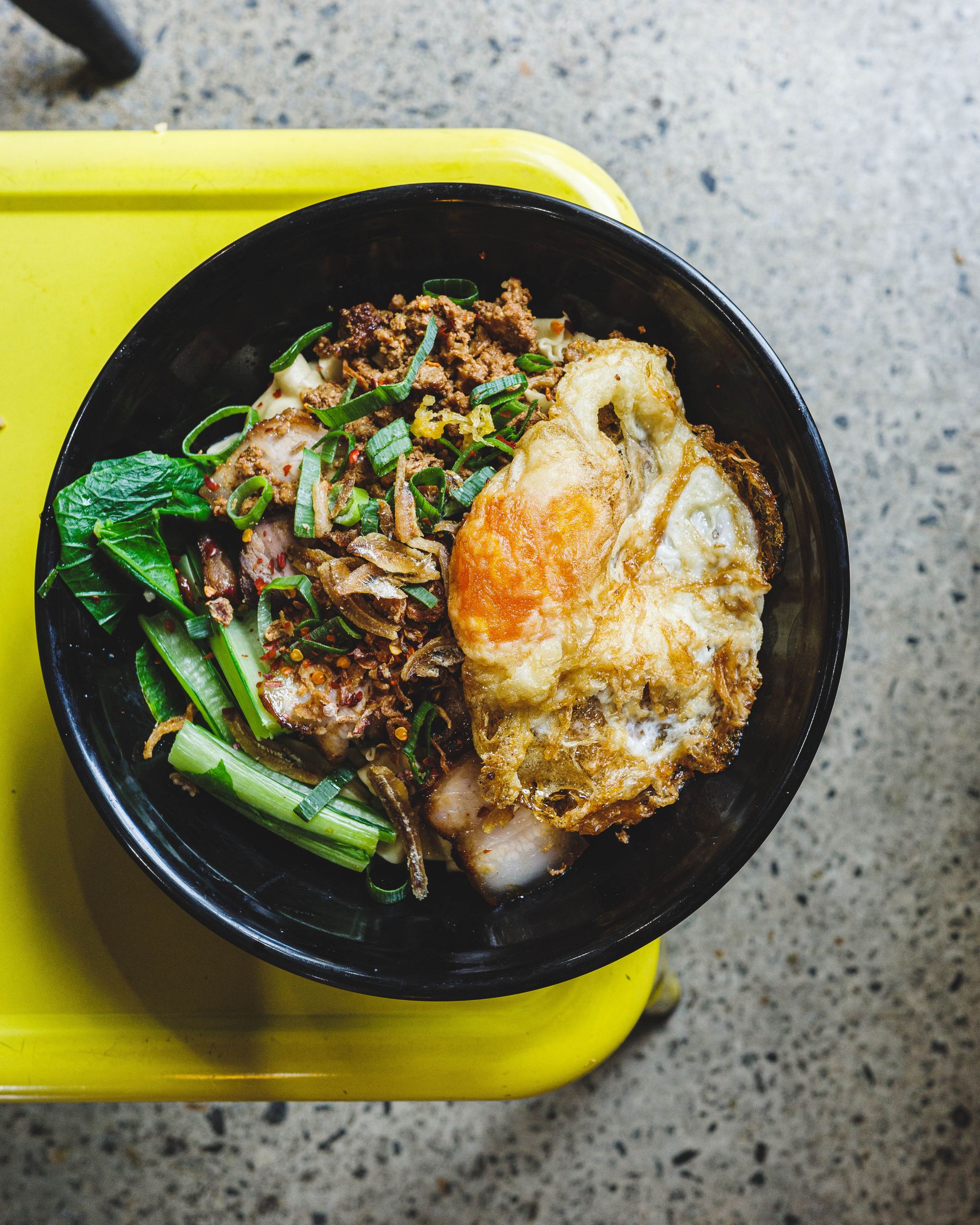 Top down shot of noodles, mince beef, Chinese vegetables and a fried egg