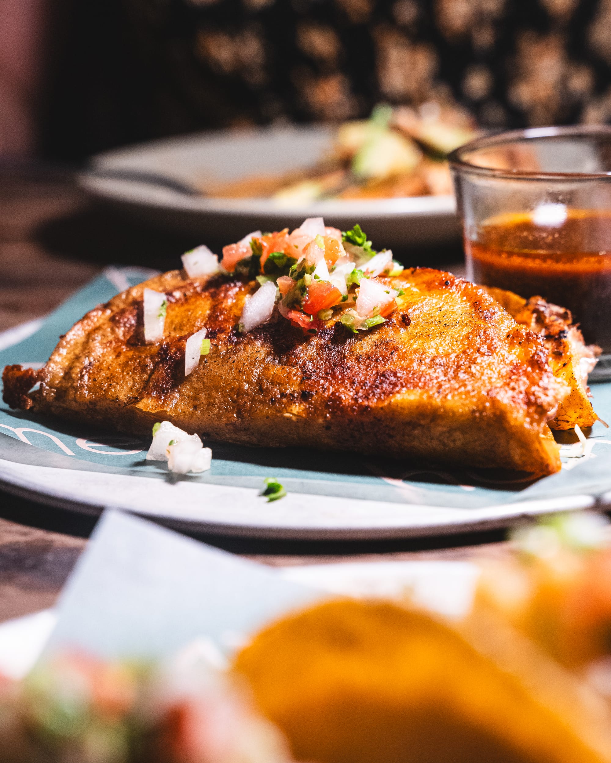 Close up of birria taco with tomato consomme on side