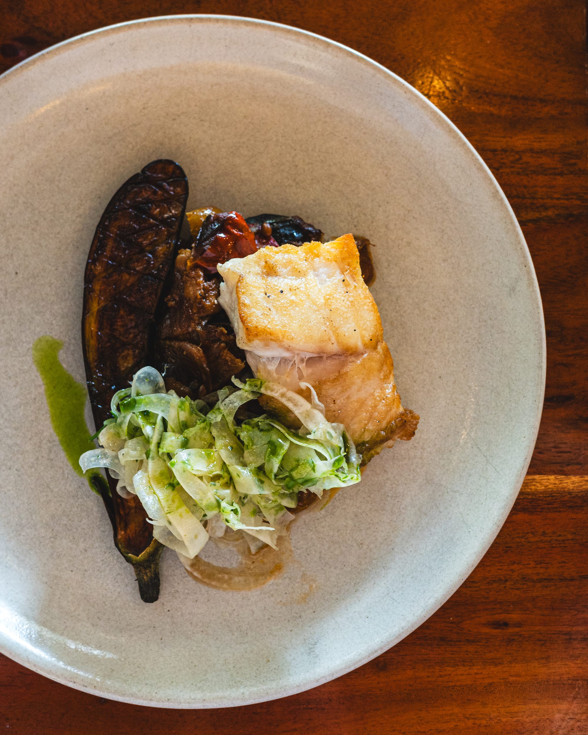 Top down shot of grilled eggplant with grilled snapper