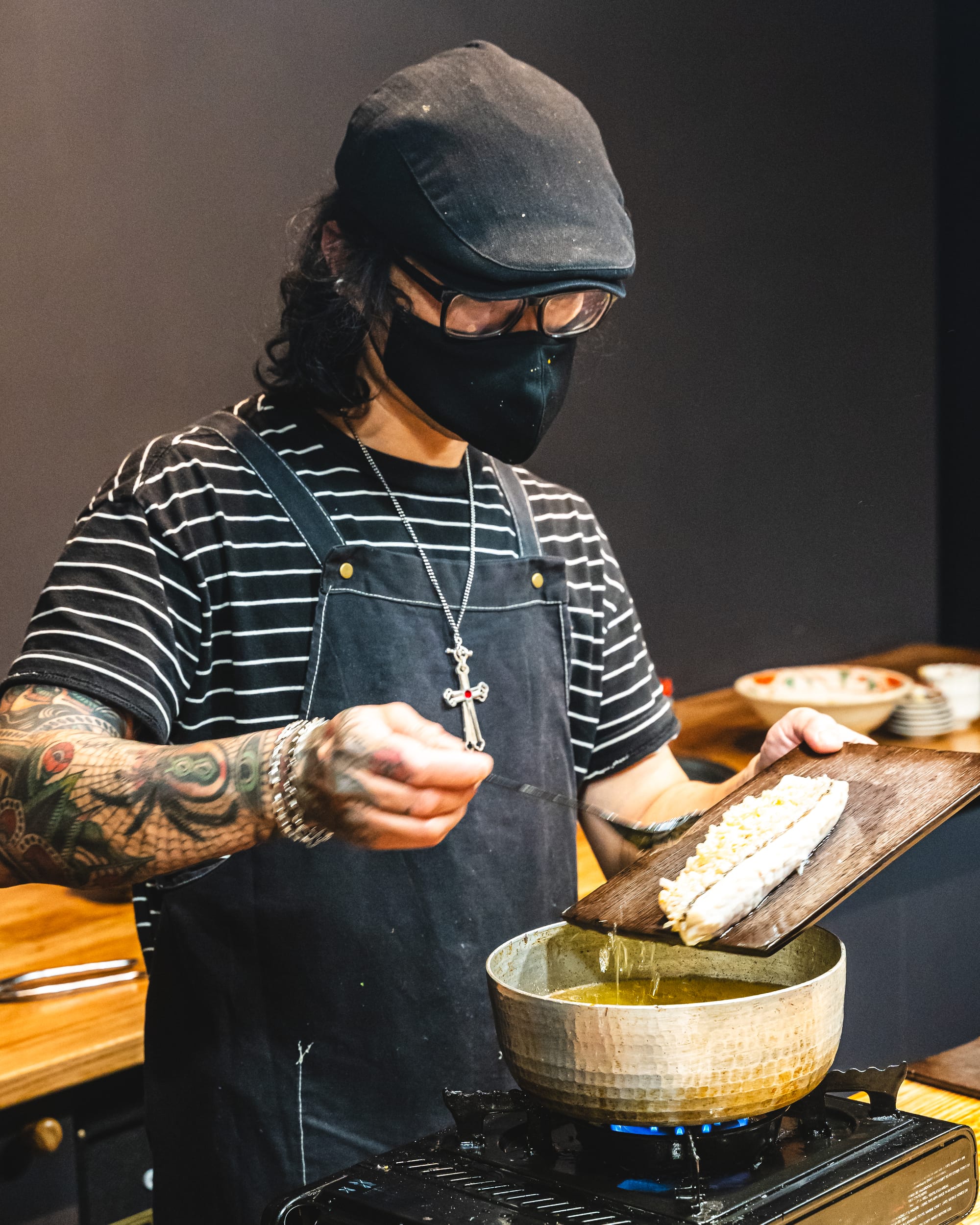 Man basting fish with oil over a saucepan