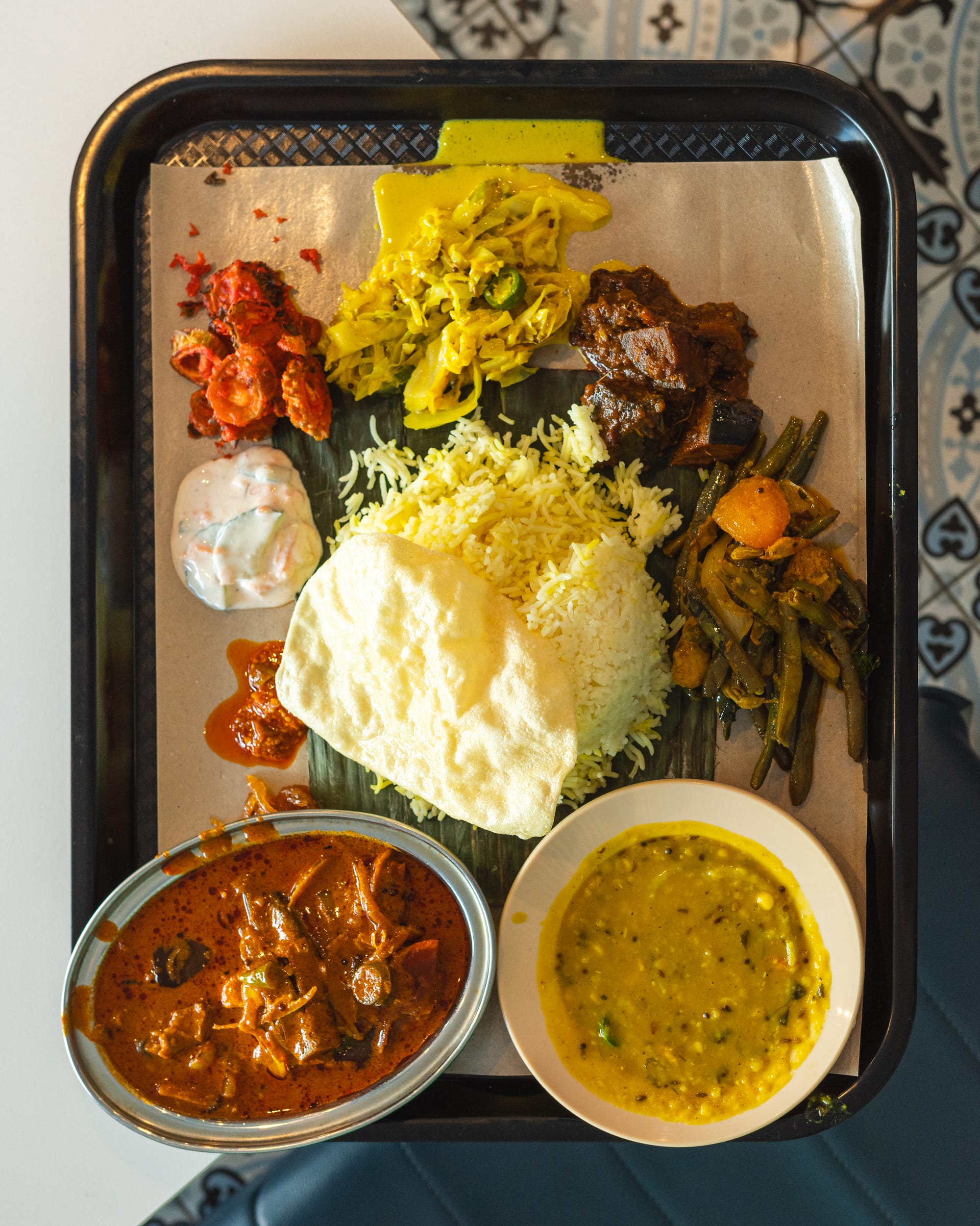 Top down shot of curry, papadum, dhal, vegetables and rice