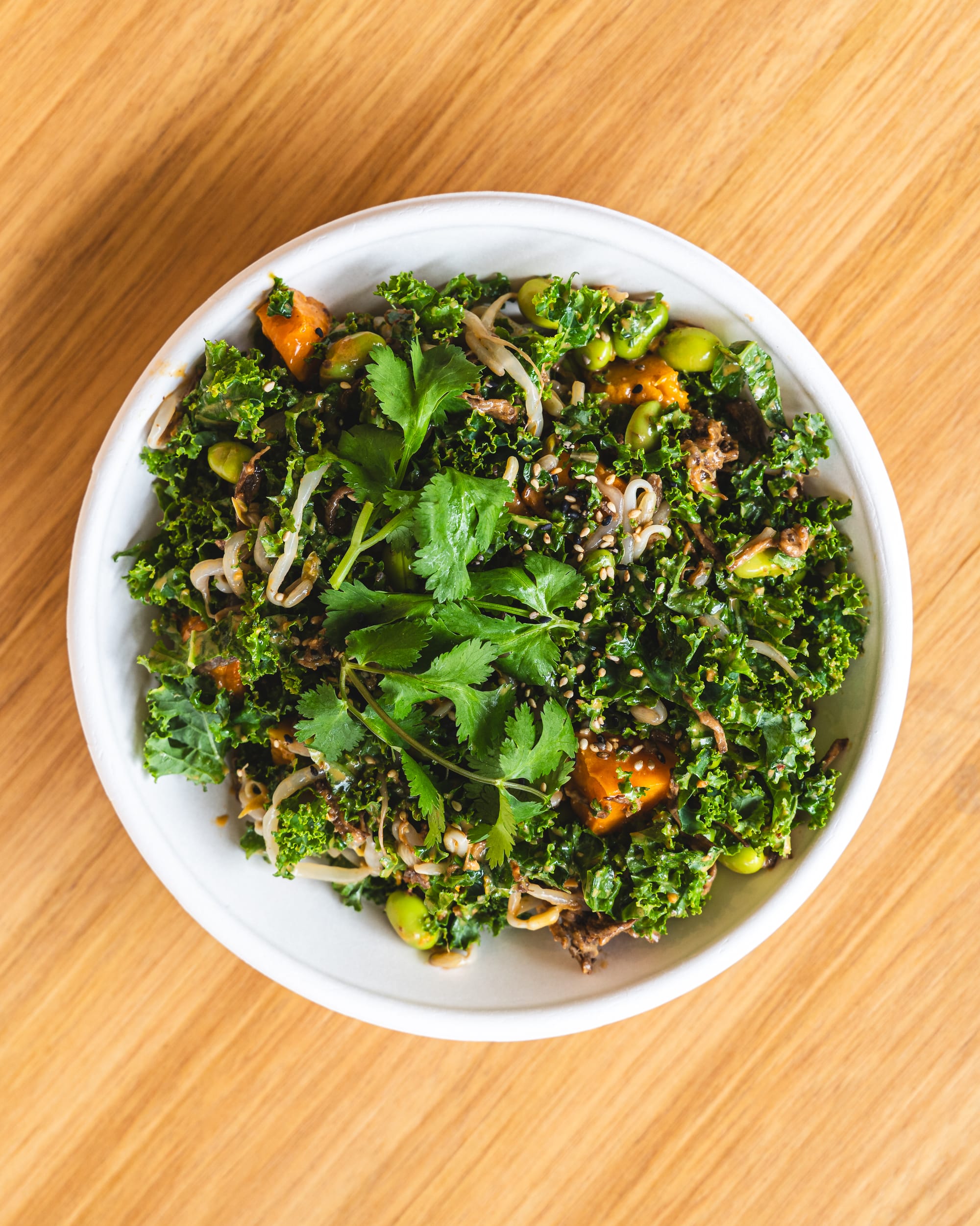 Top down shot of poke bowl with kale, coriander, beef, edamame and pumpkin showing