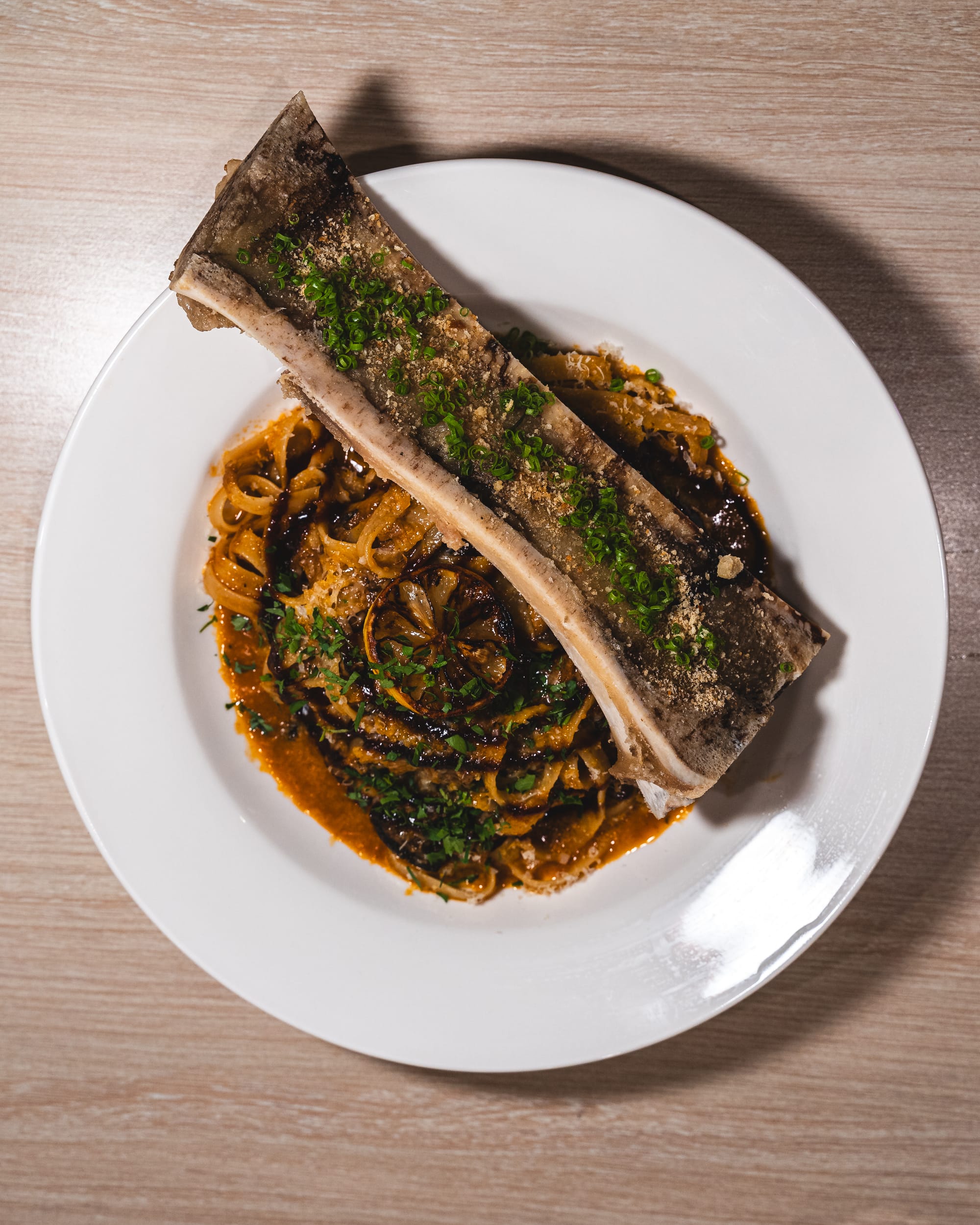 Top down shot of bone barrow on top of a plate of pasta