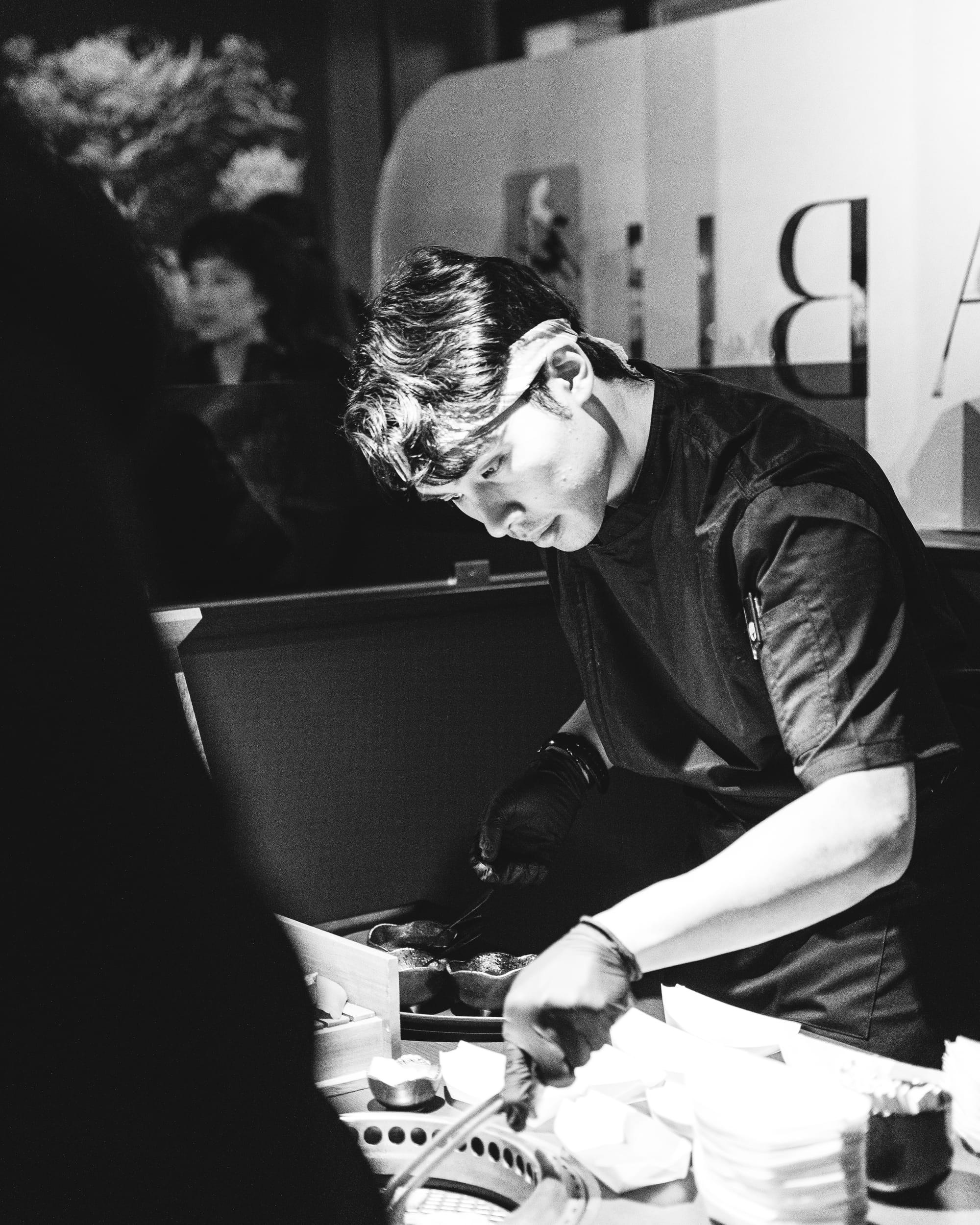 Black and white photo of chef grilling wagyu on a grill