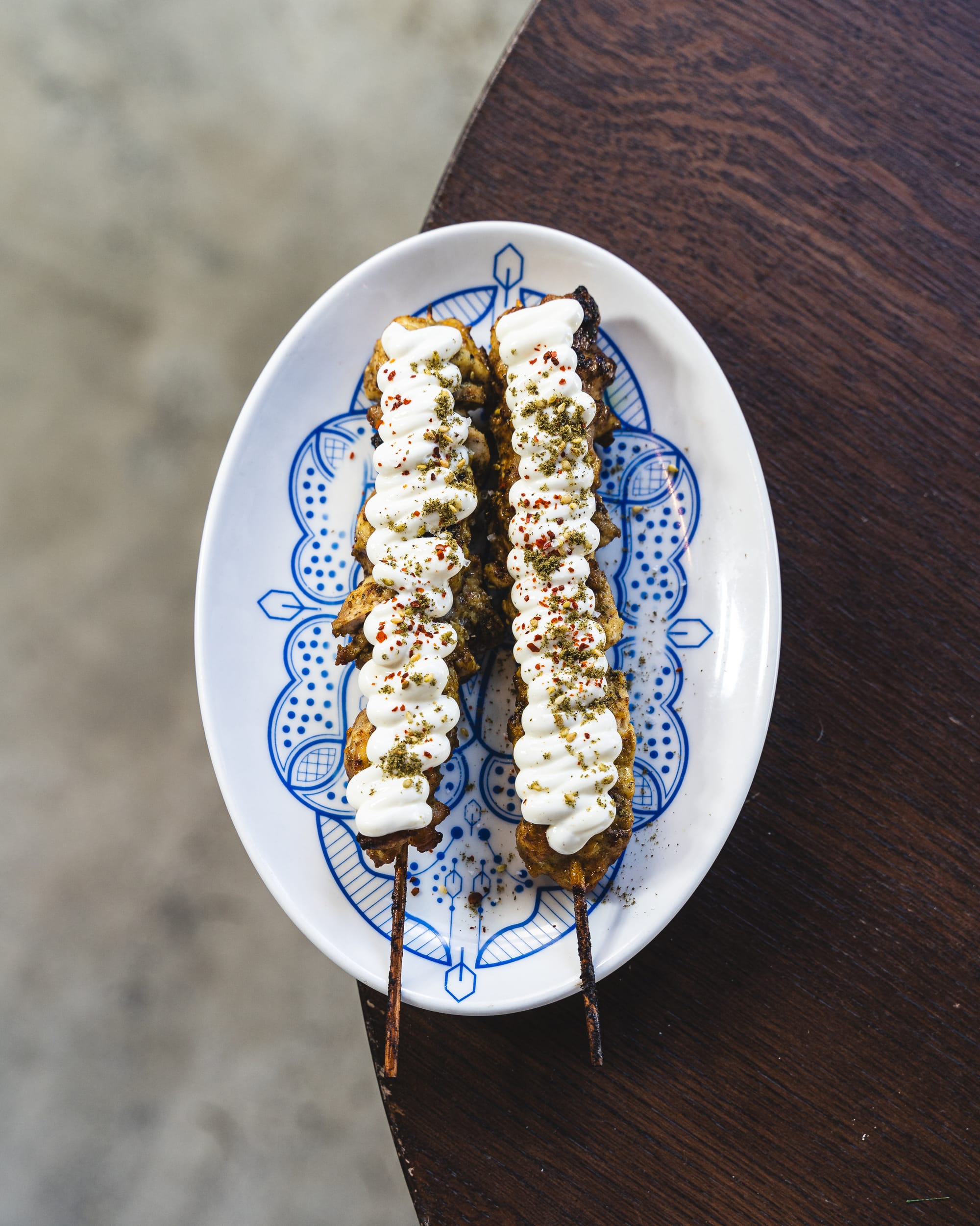 Top down shot of chicken skewers with yoghurt sauce