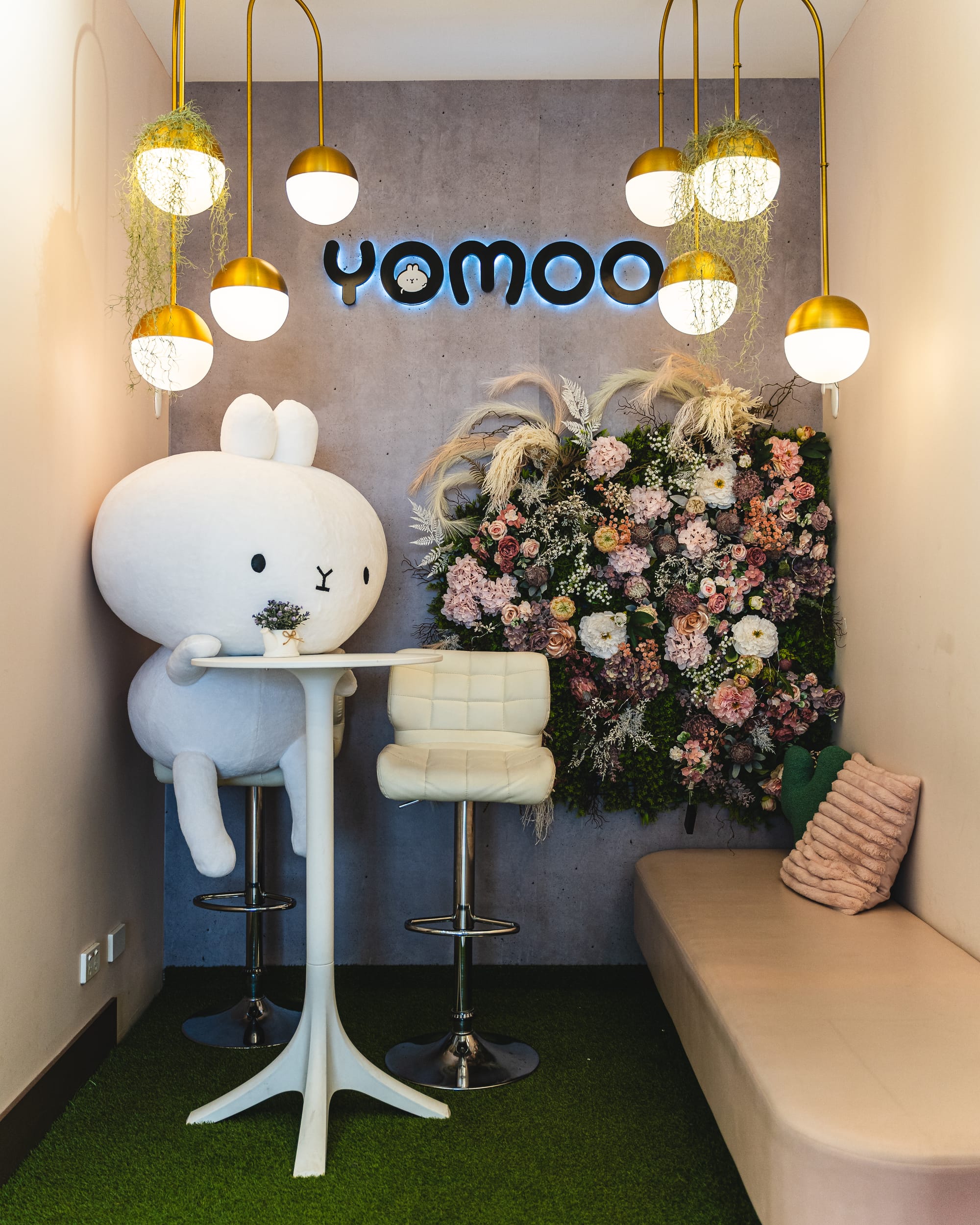 Interior of YoMoo showing YoMoo mascot and a flower wall