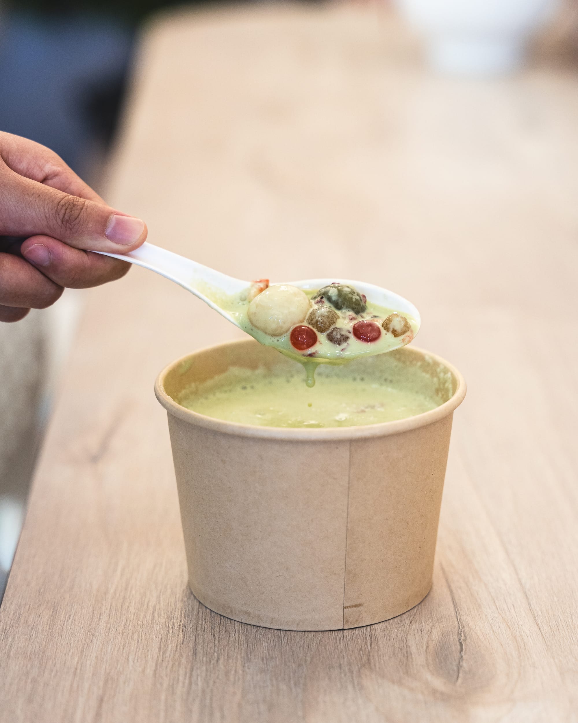 Hand scooping fruit in yoghurt