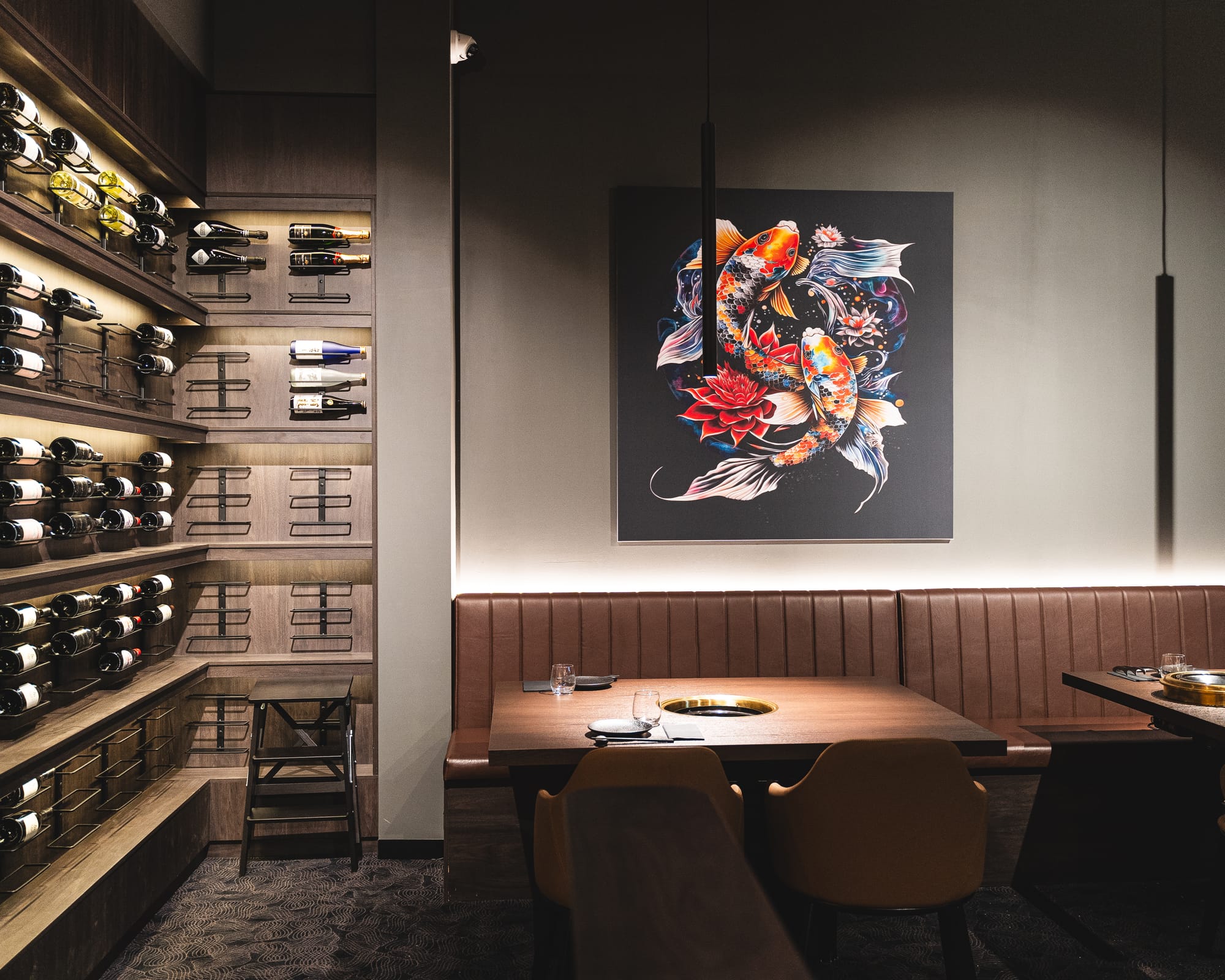 Interior shot of restaurant showing artwork and wine bottles on wall