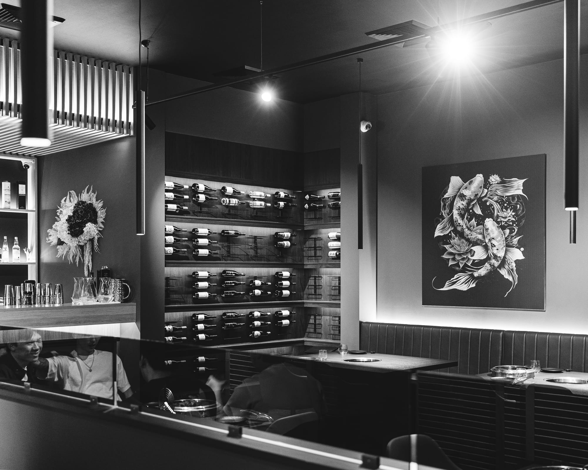 Interior shot of restaurant showing artwork and wine bottles on wall