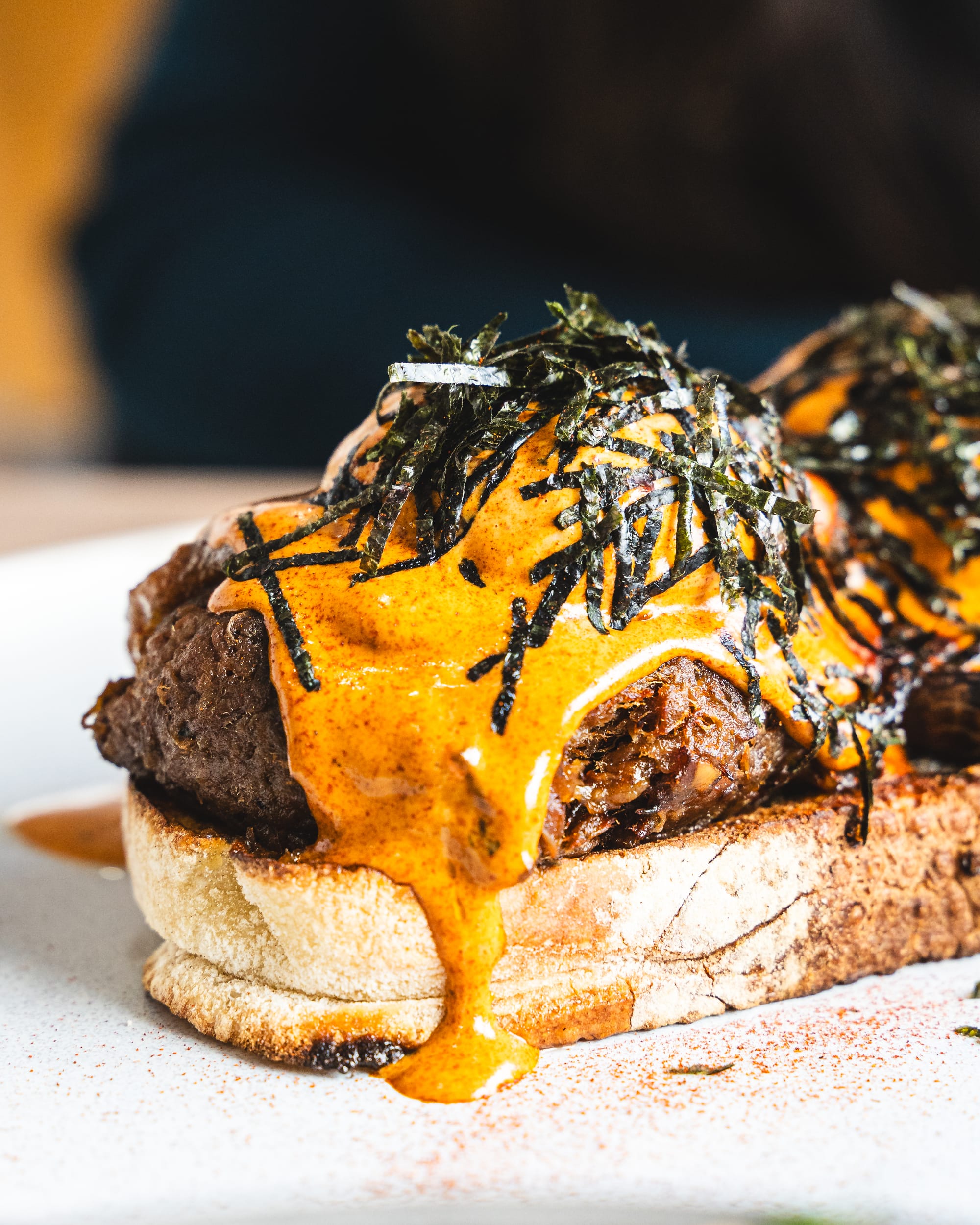 Close up shot of pulled beef with eggs benedict and seaweed 