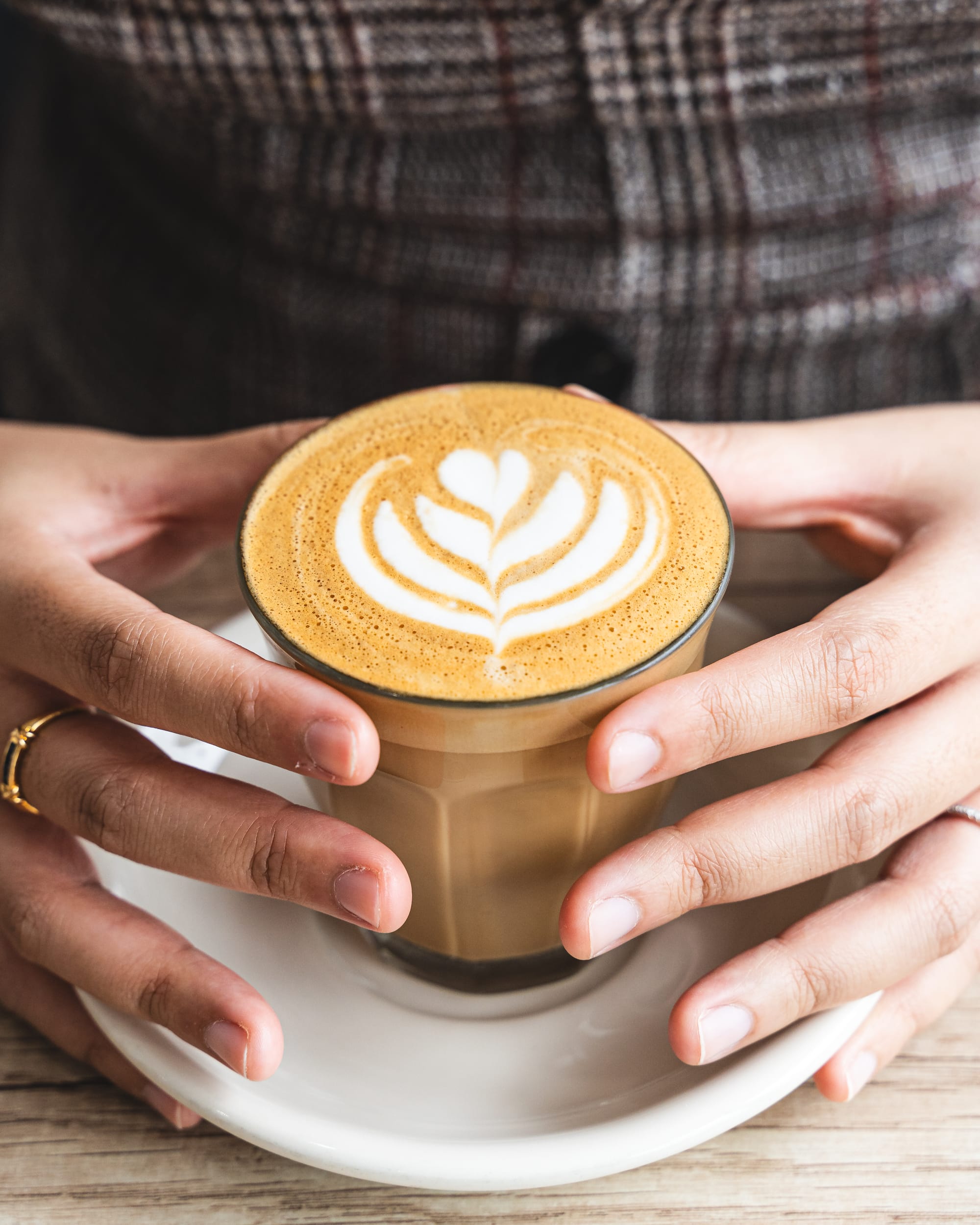 Close up of hands holding a coffee mug with latte art