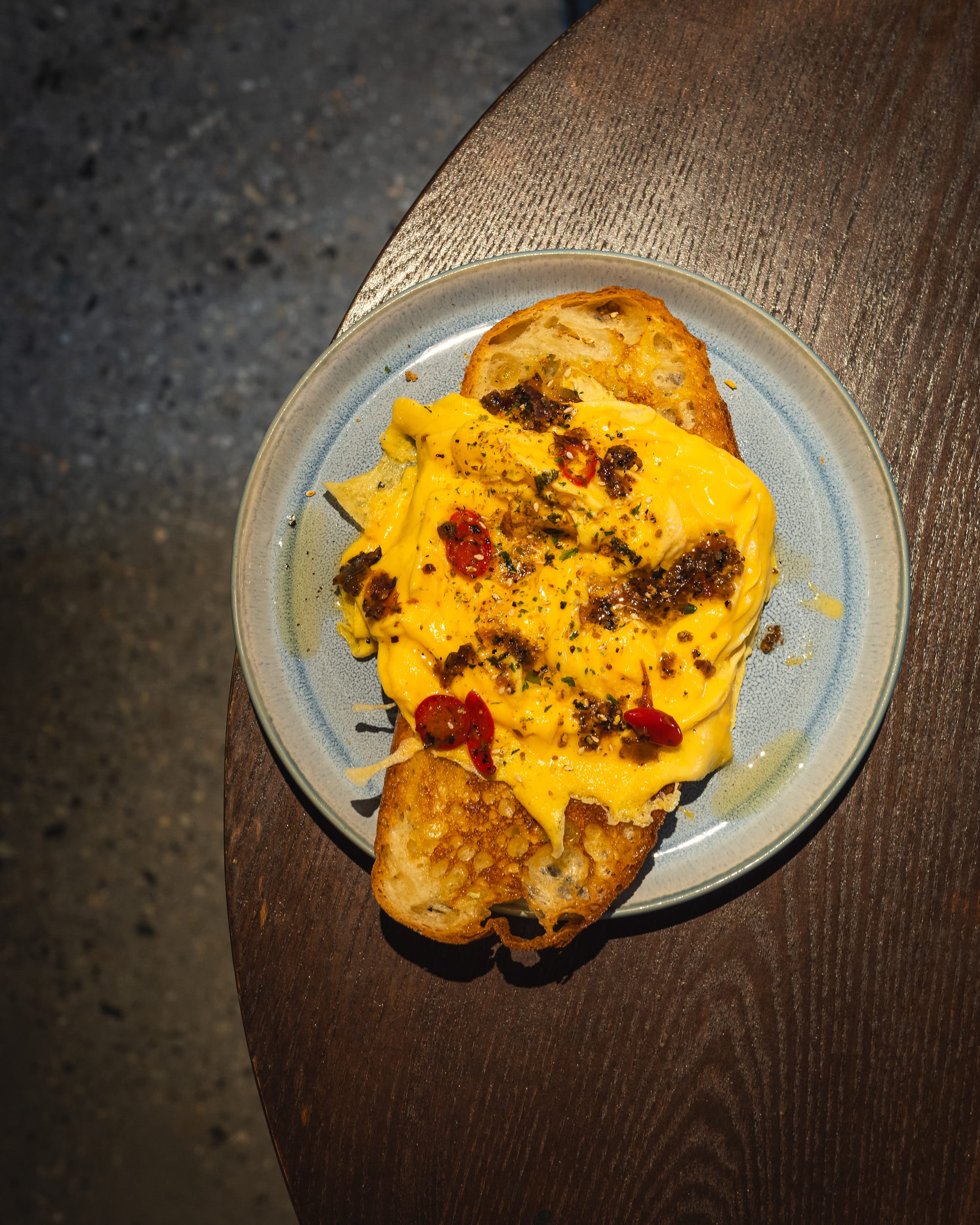 Top down shot of scrambled eggs served on a slice of bread