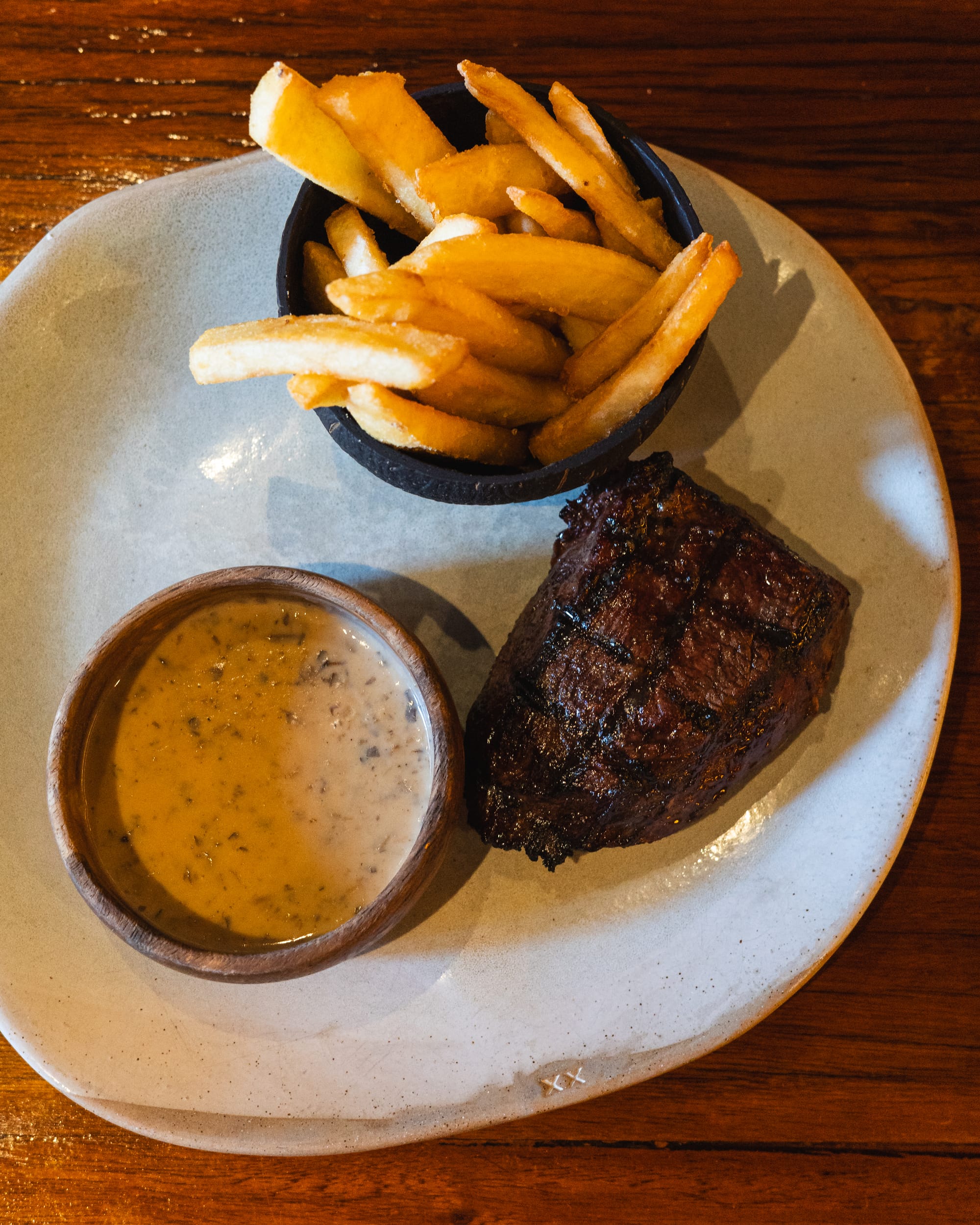 Top down shot of grilled rump steak, chips and mushroom sauce