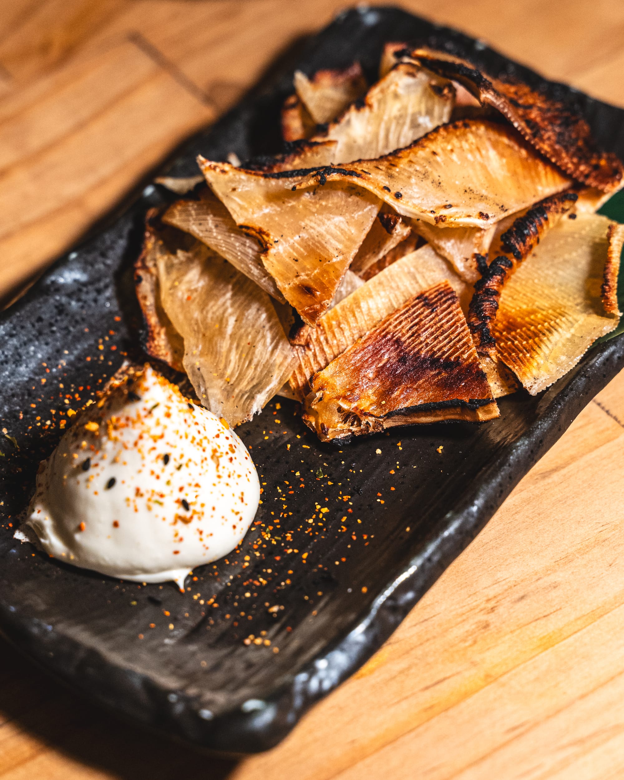 Close up of grilled stingray fins with a side of kewpie mayo