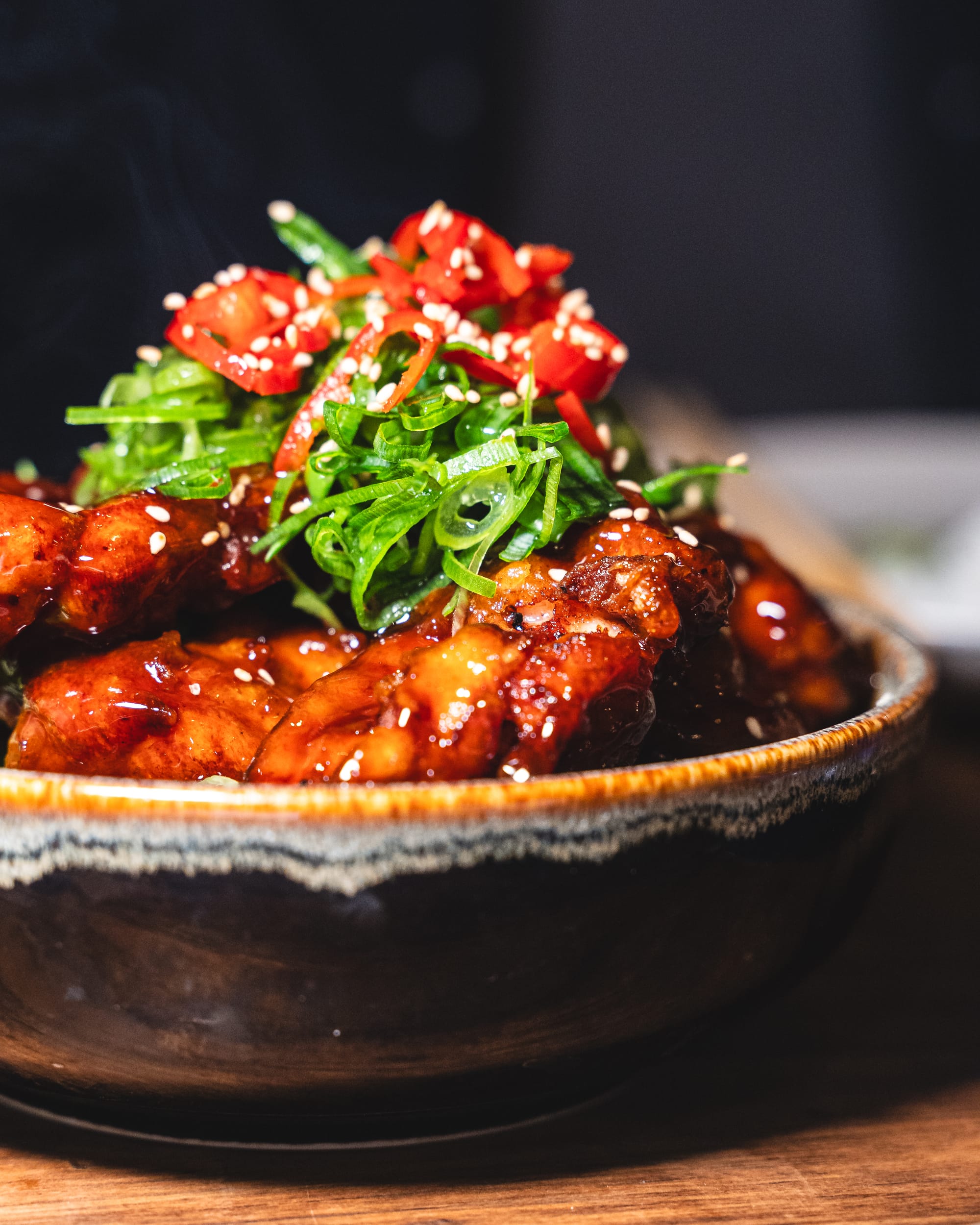 Close up of karaage chicken with chilli sauce and srping onion