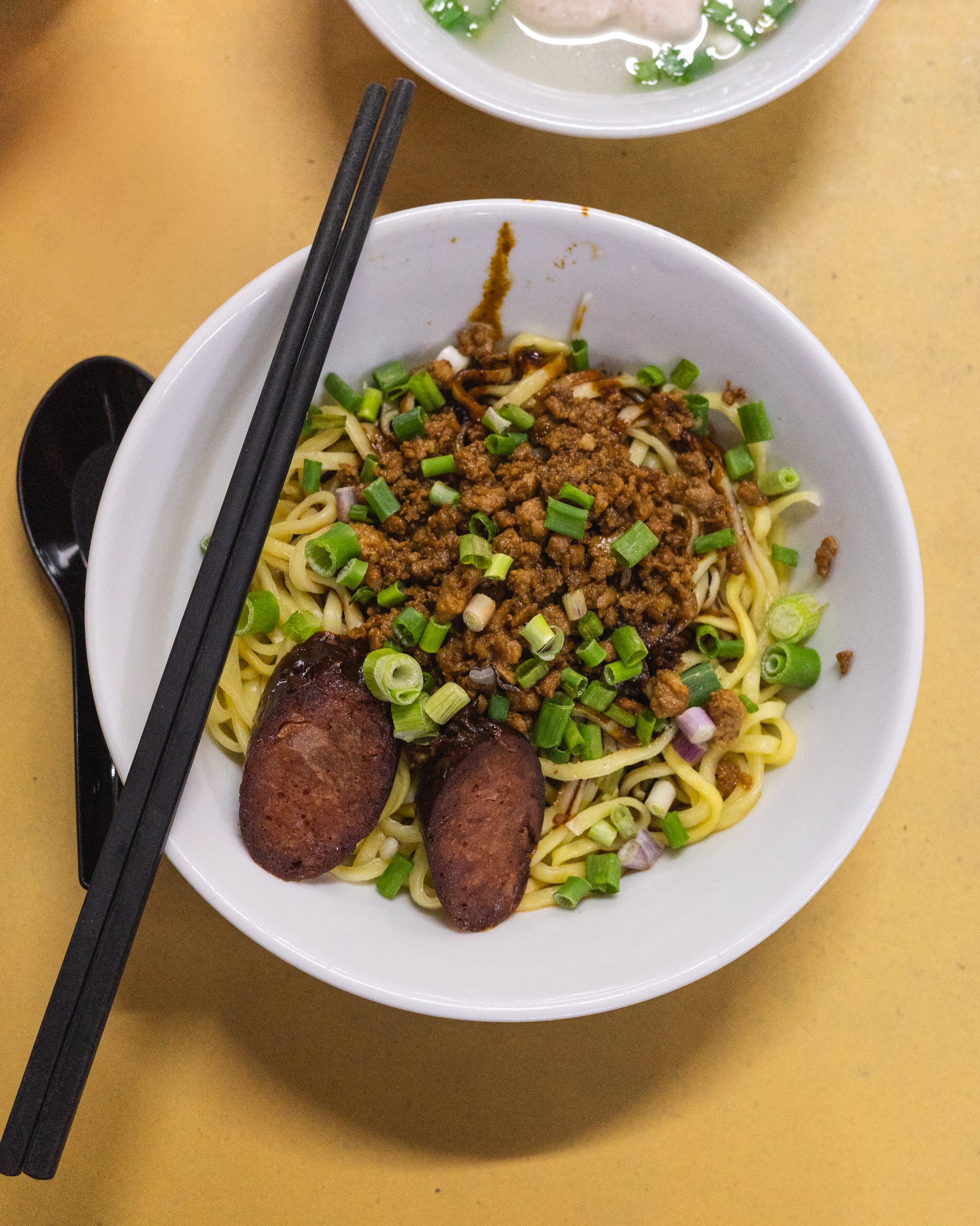 Top down shot of noodles topped with mince meat and sausage